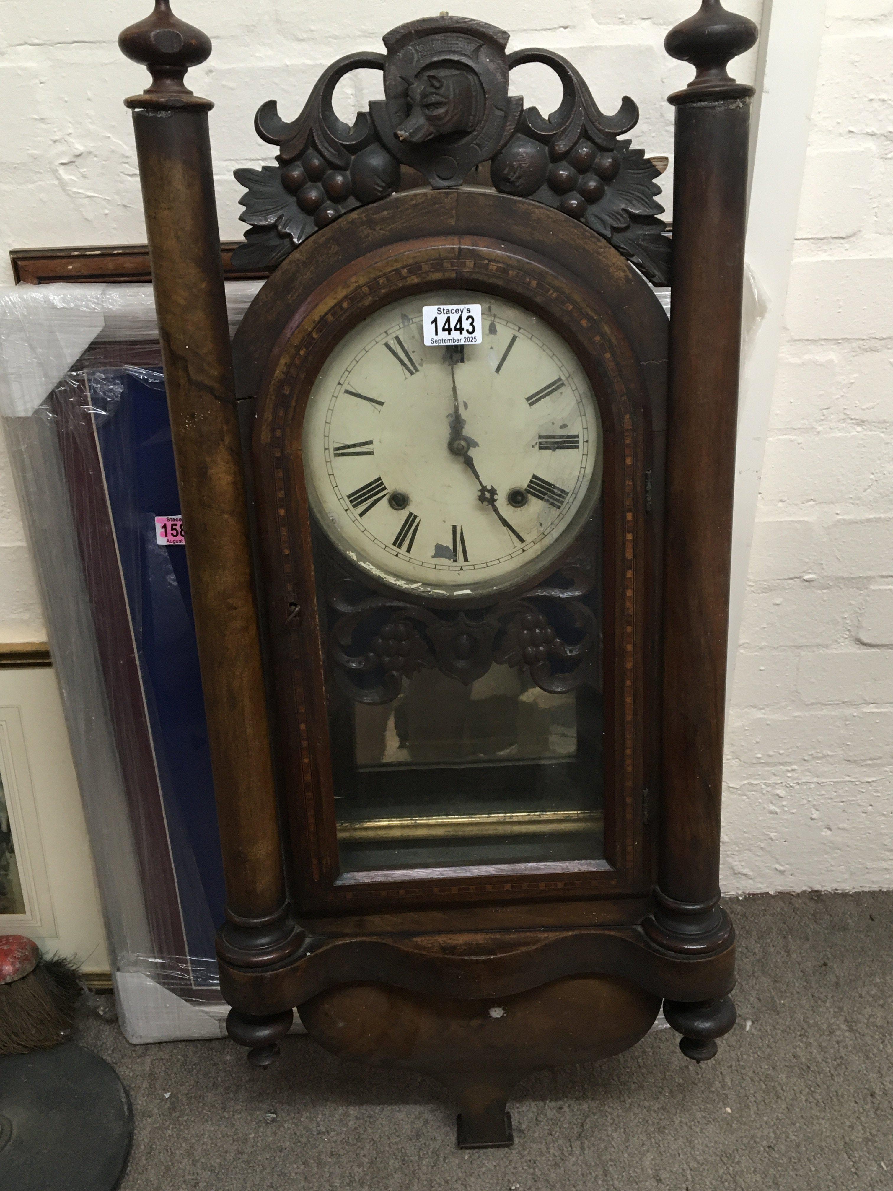 A late Victorian walnut cased wall clock with ornamental pillars and applied carving Height 98cm