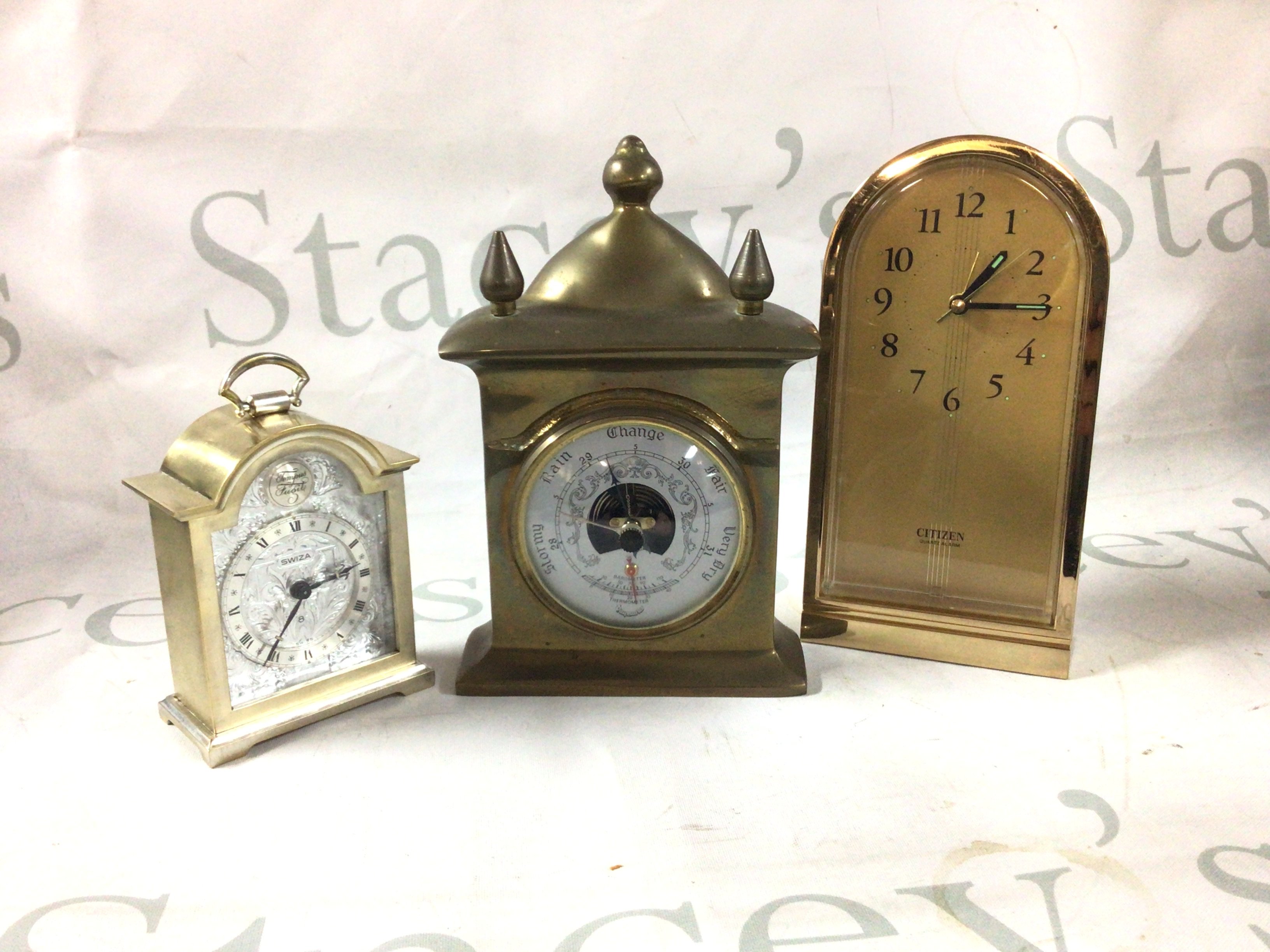 A box of mantle clocks and one barometer.