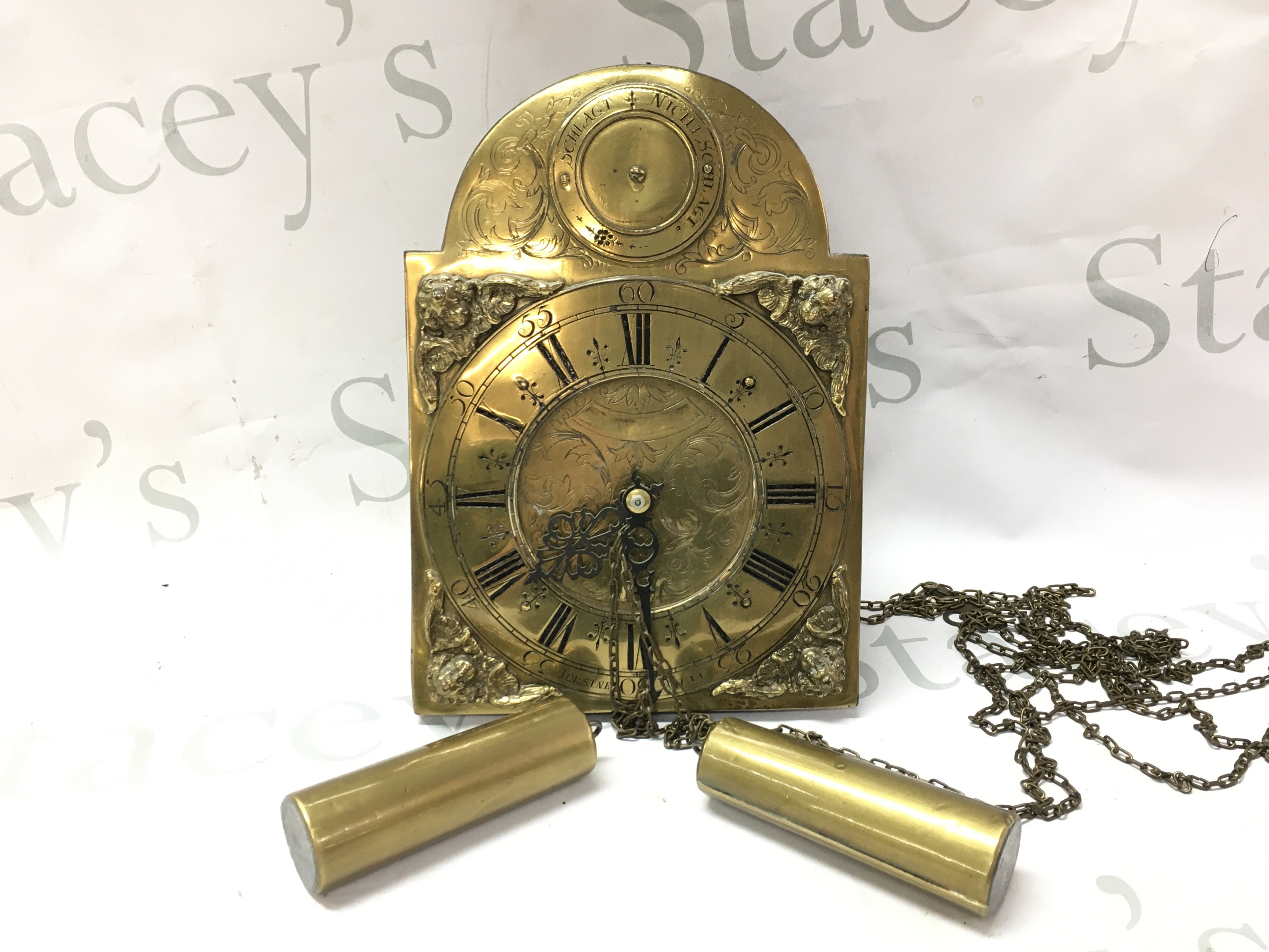 A German brass wall clock with weights . Postage category C