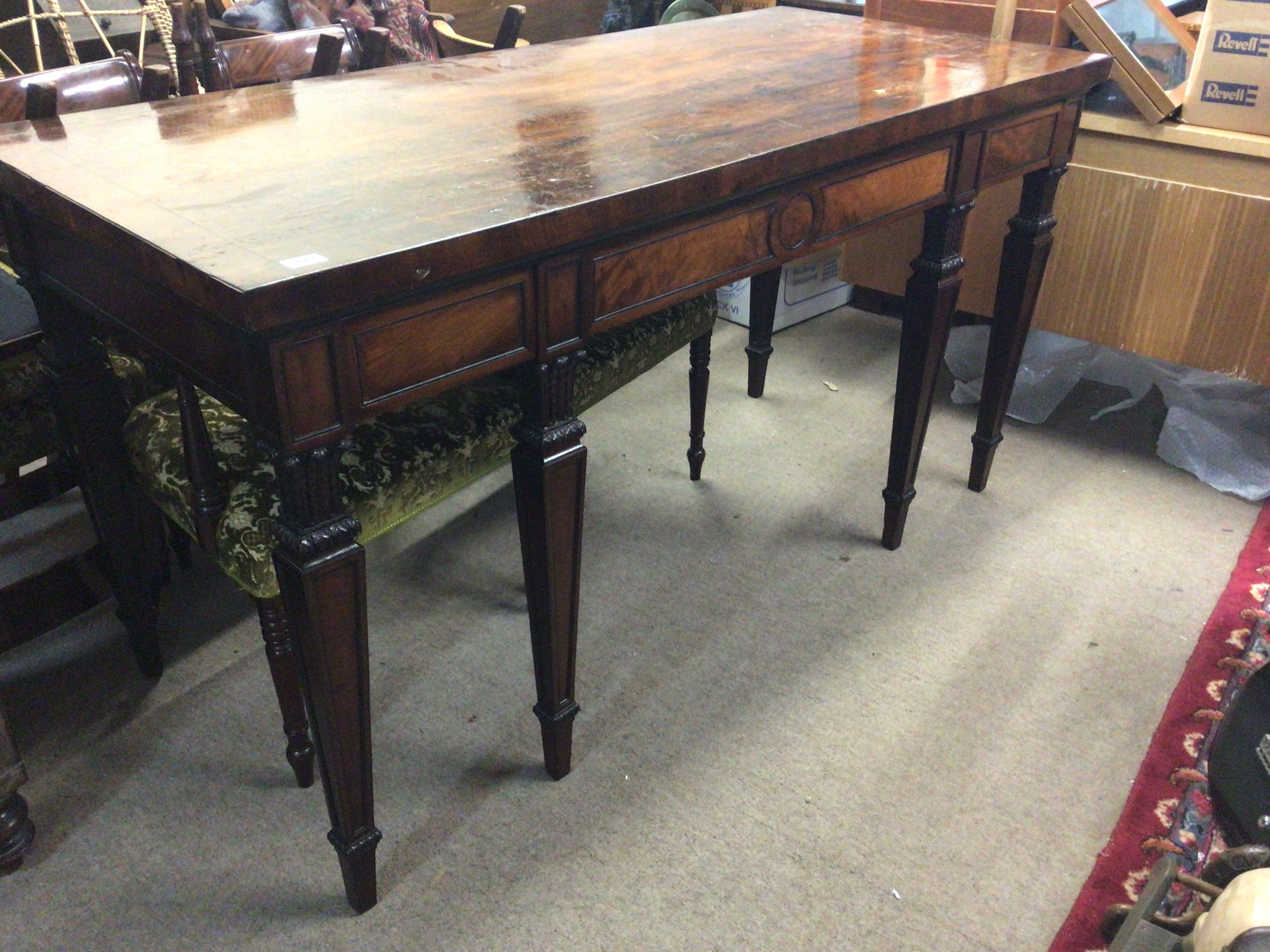 A quality George III Mahogany dining room serving table the rectangular top with an ebony banding above three drawers with four front tapering legs with stylised acanthus leave capitals 168cm long 88cm high 75cm deep.