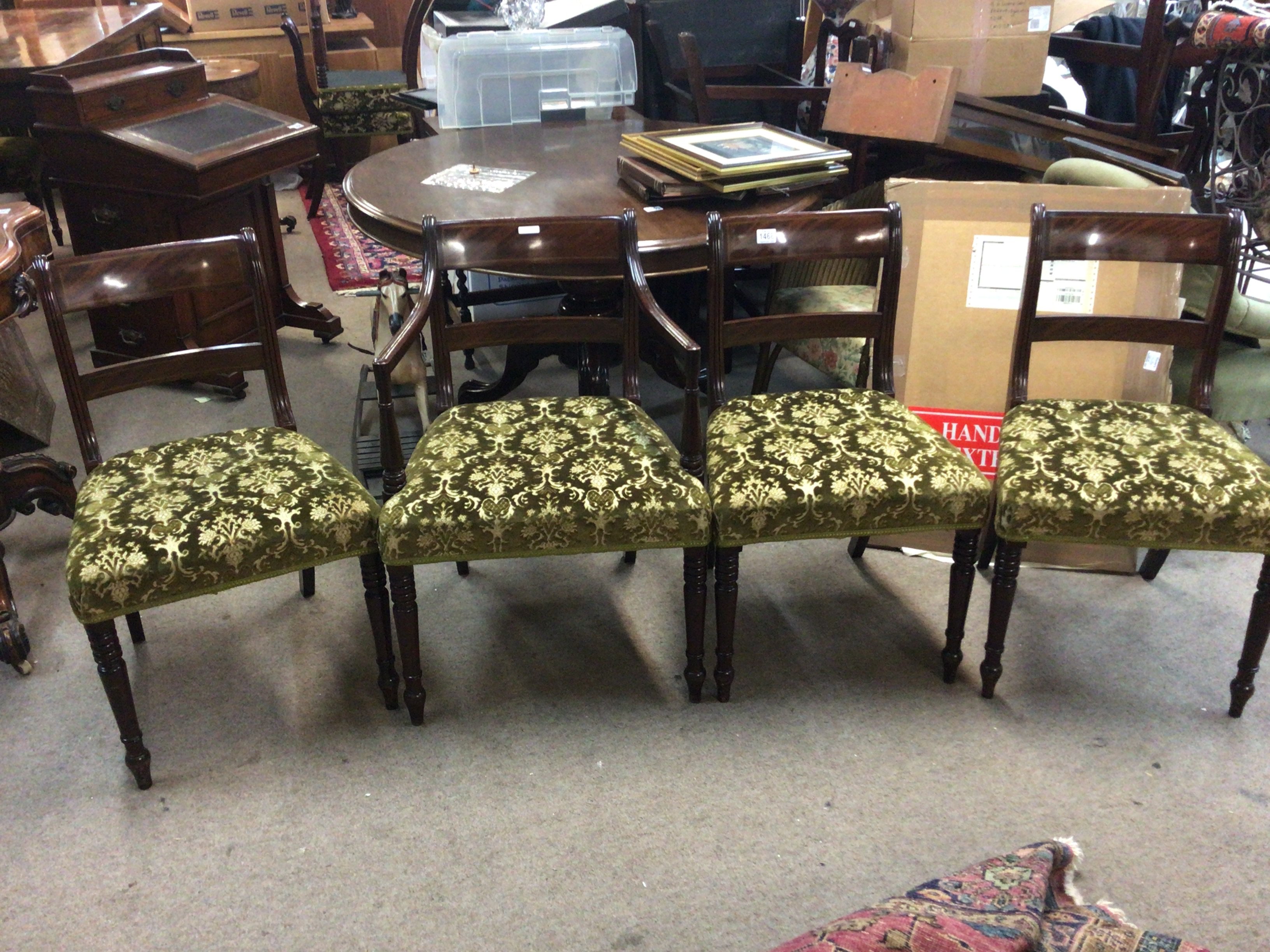 A set of twelve matching mahogany dining chairs including two carver chairs with inlaid backs green patterned upholstered seats and ring turned legs. This is a Harlequin set some chairs of the Period late George III with quality retrospective matching copys (10)