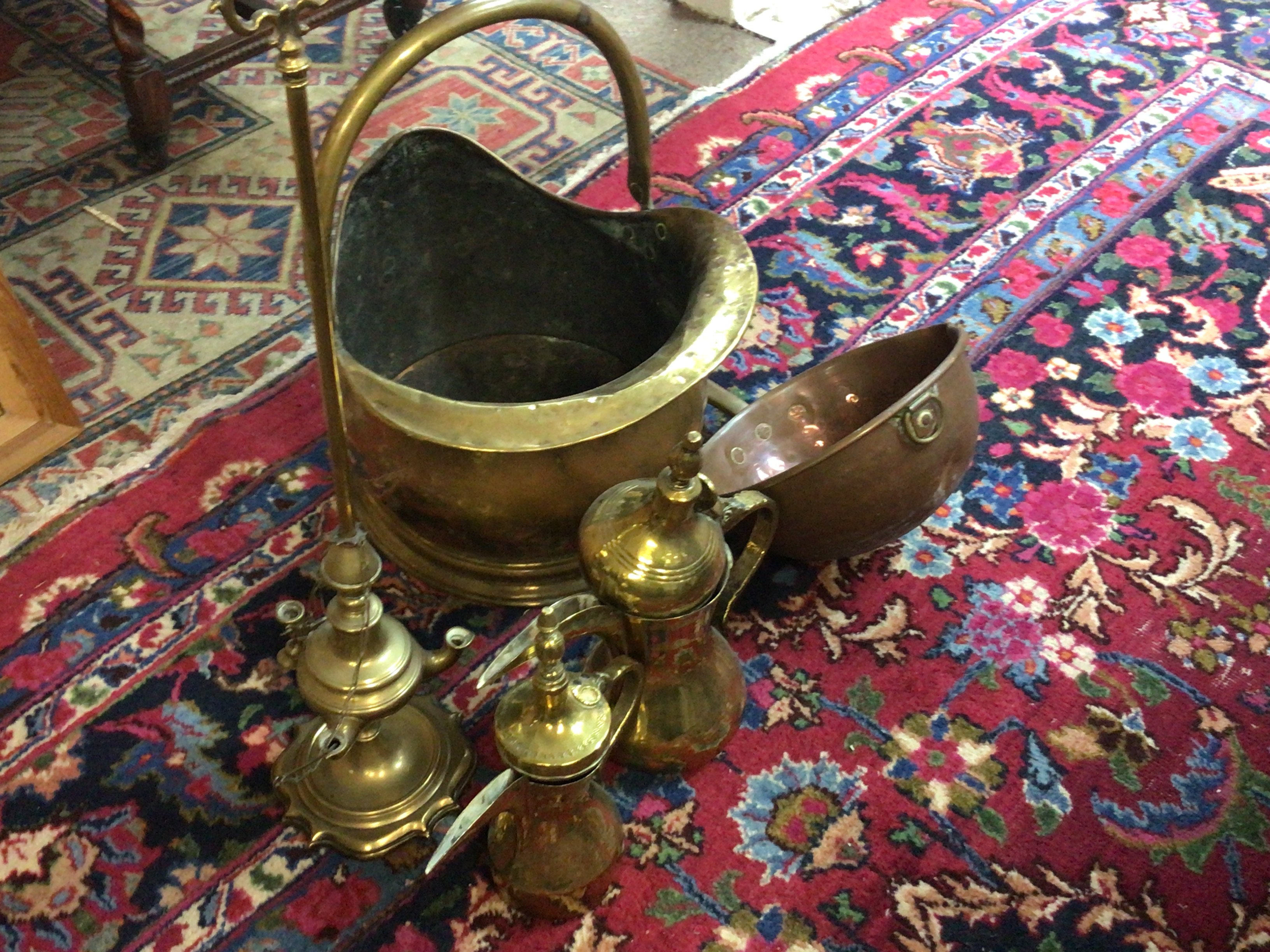 A brass coal scuttle and other copper and brass ware including a lamp.