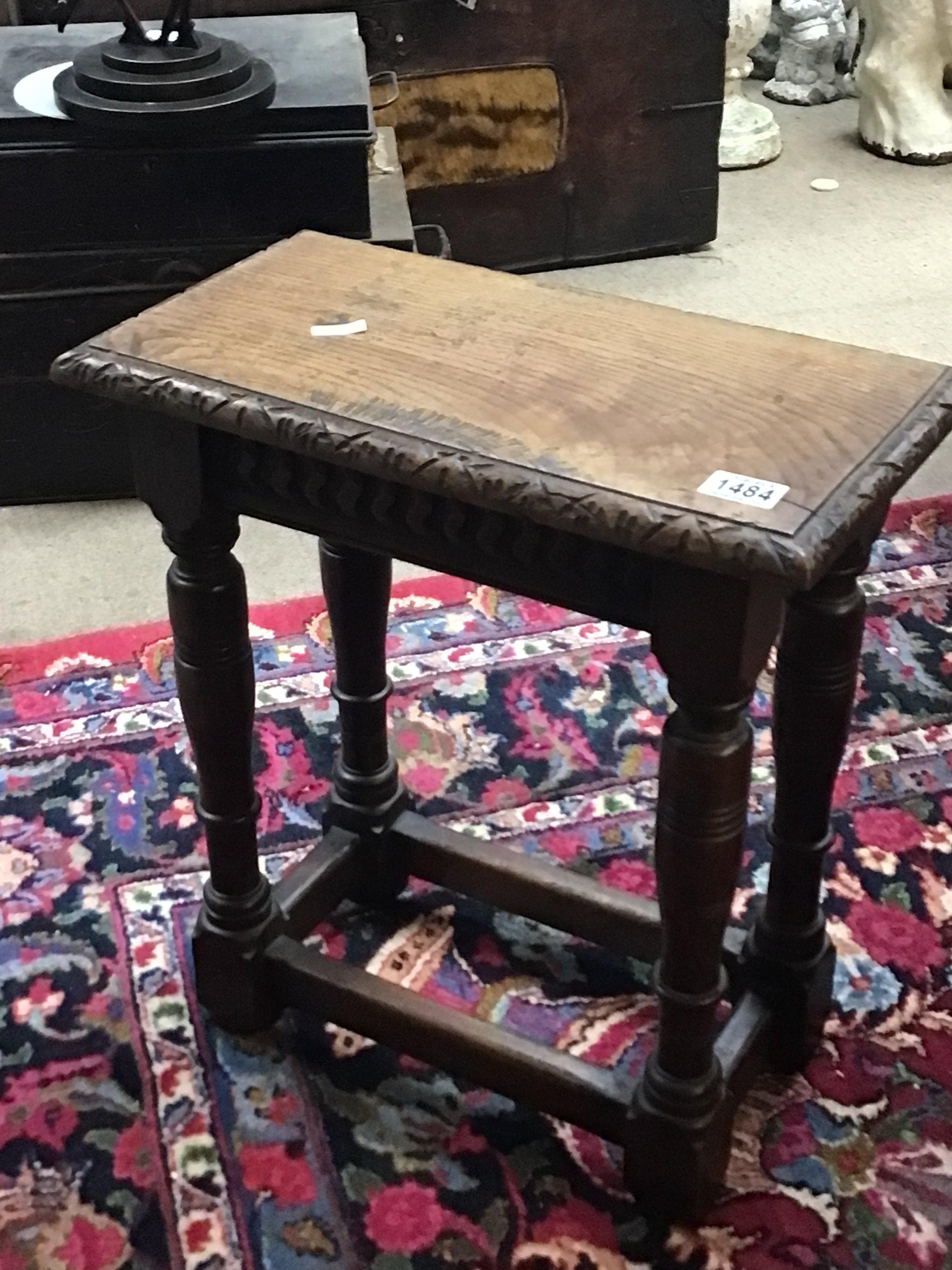 An Early 19th century English Vernacular carved oak coffin stool the top with carved edge on turned legs united by stretchers. Hight 51cm