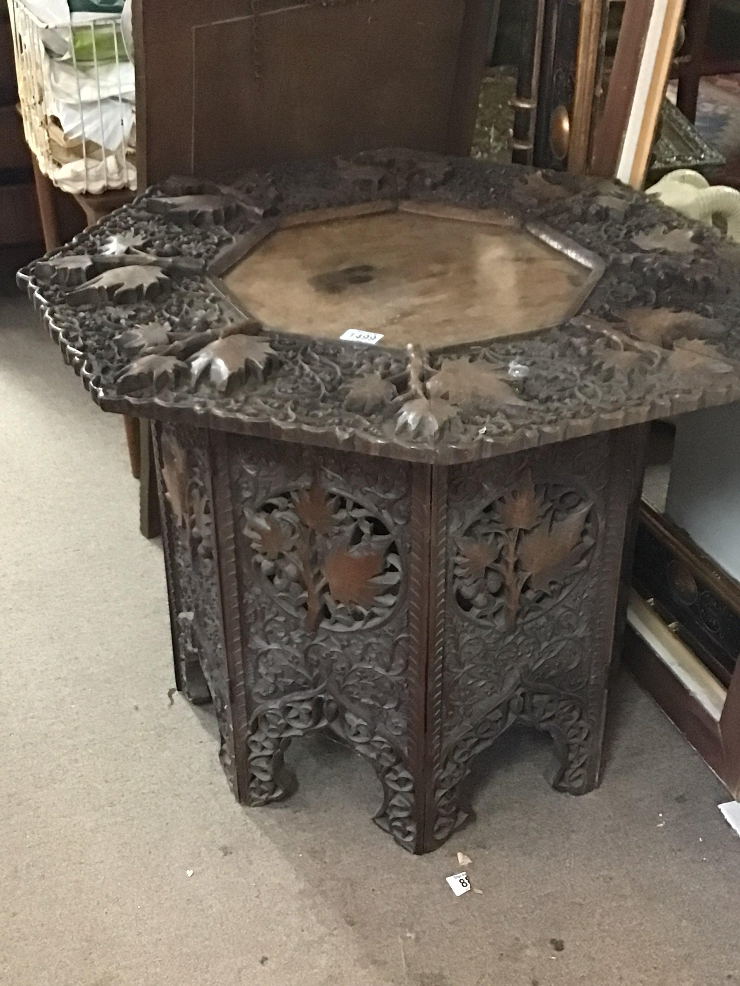 A profusely carved hardwood occasional table the hexagonal top with raised foliage height 58cm