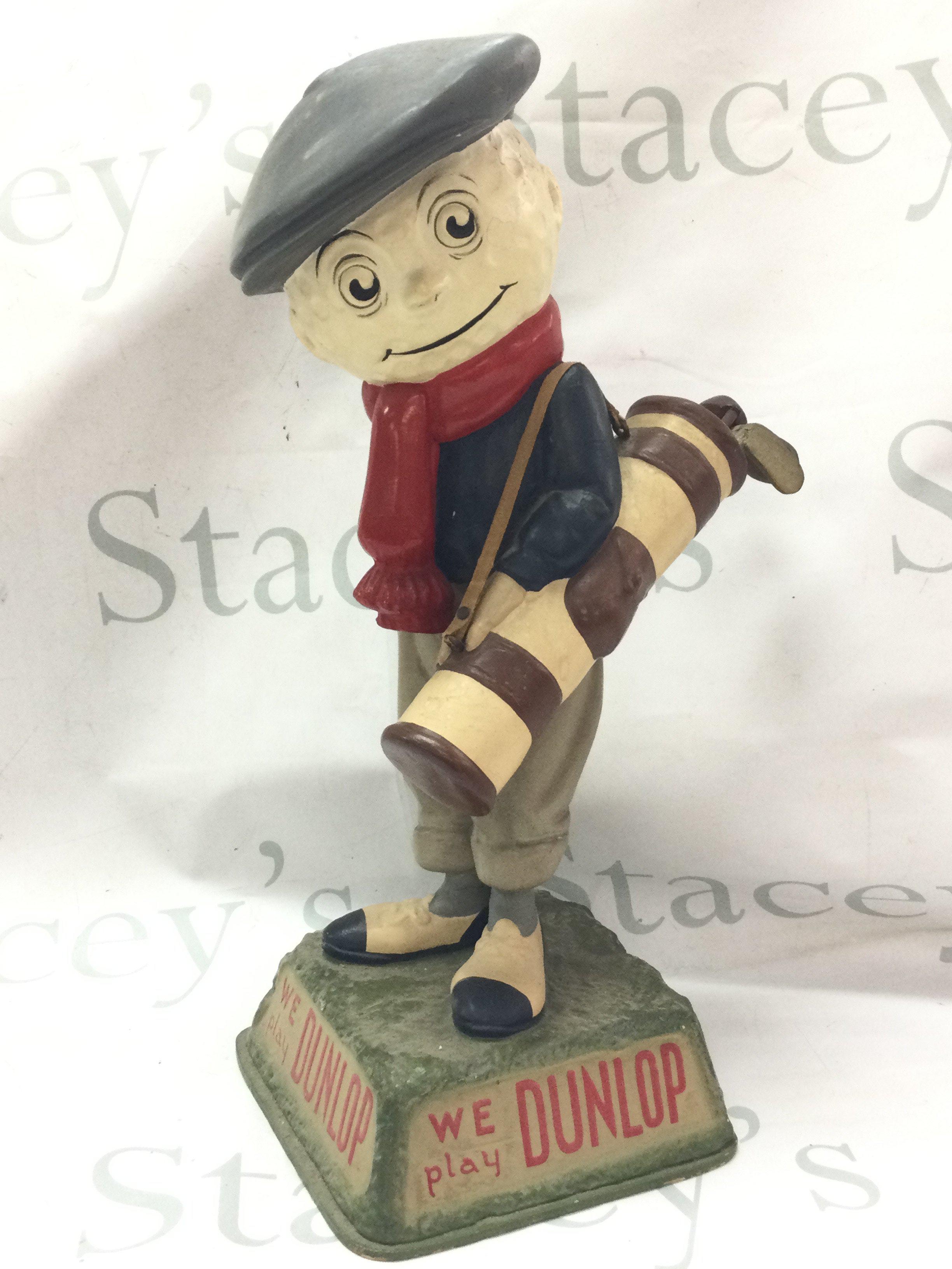 A vintage We Play Dunlop golf advertising figure , 39cm tall.