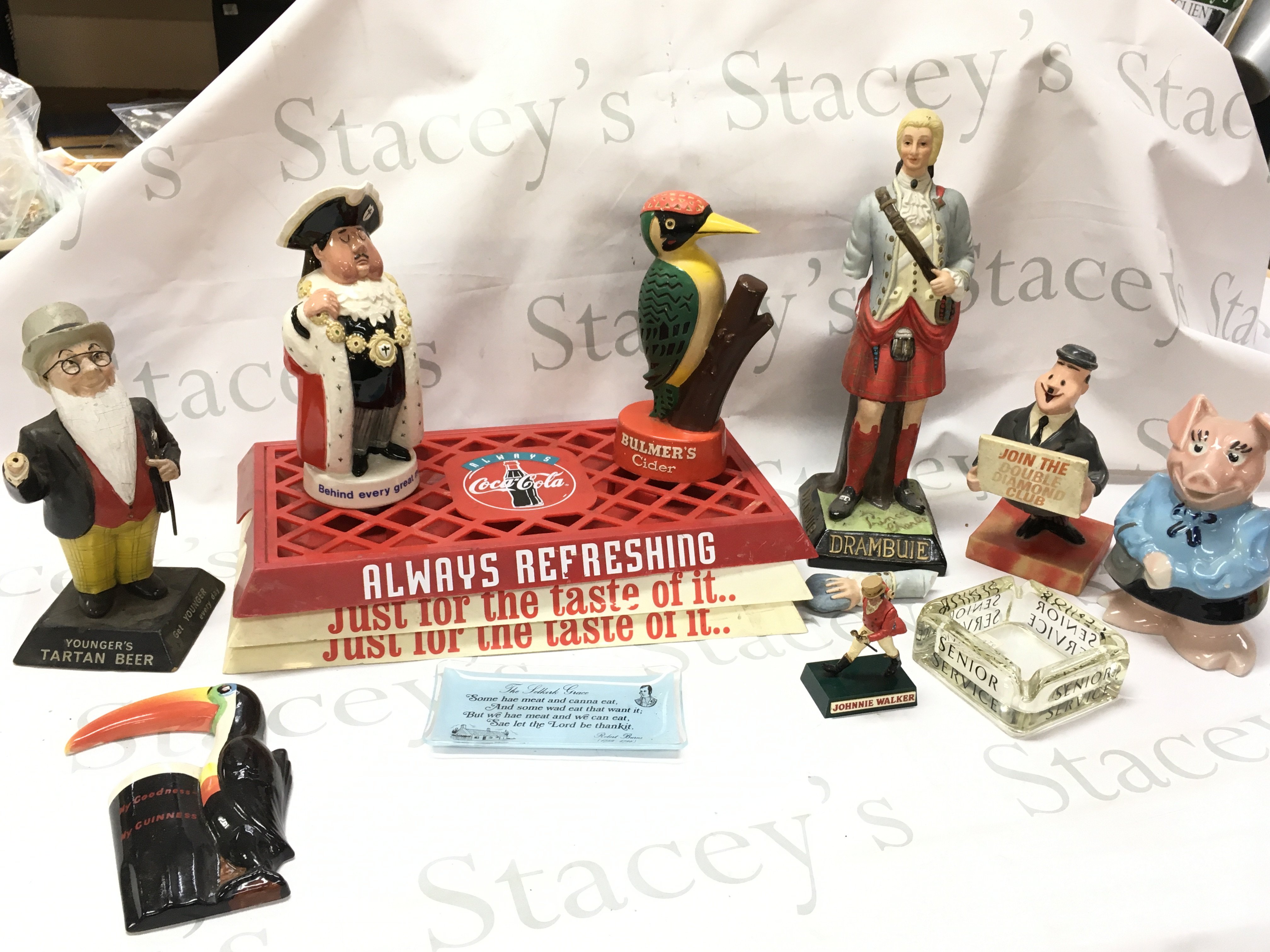 Pub advertising figures including Worthingtons behind every great man Beswick porcelain figure, a Youngers Tartan beer, Bulmers cider, Drambuie, porcelain Guinness toucan wall plaque by Carltonware. ( damaged) , Coca Cola tray etc . Also including a box of other merchandise including a Players cigarettes dish, Britivic dish etc .This lot cannot be posted