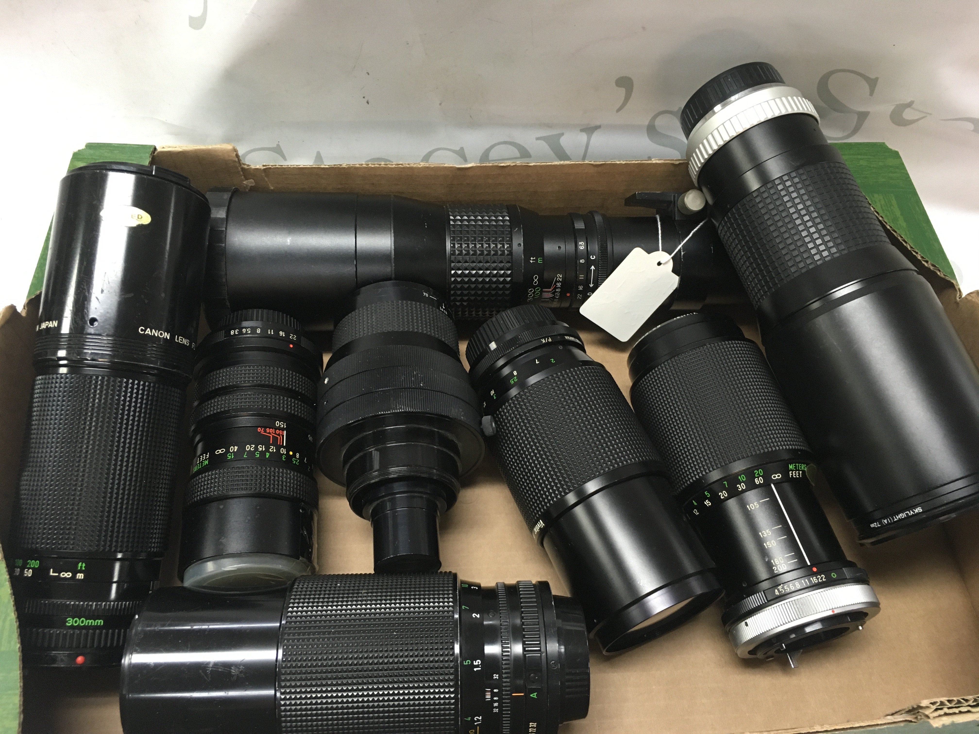 A box of eight large camera lenses including Senator 400mm, Hoya HMC tele auto 400mm, Canon 300mm. Postage category C