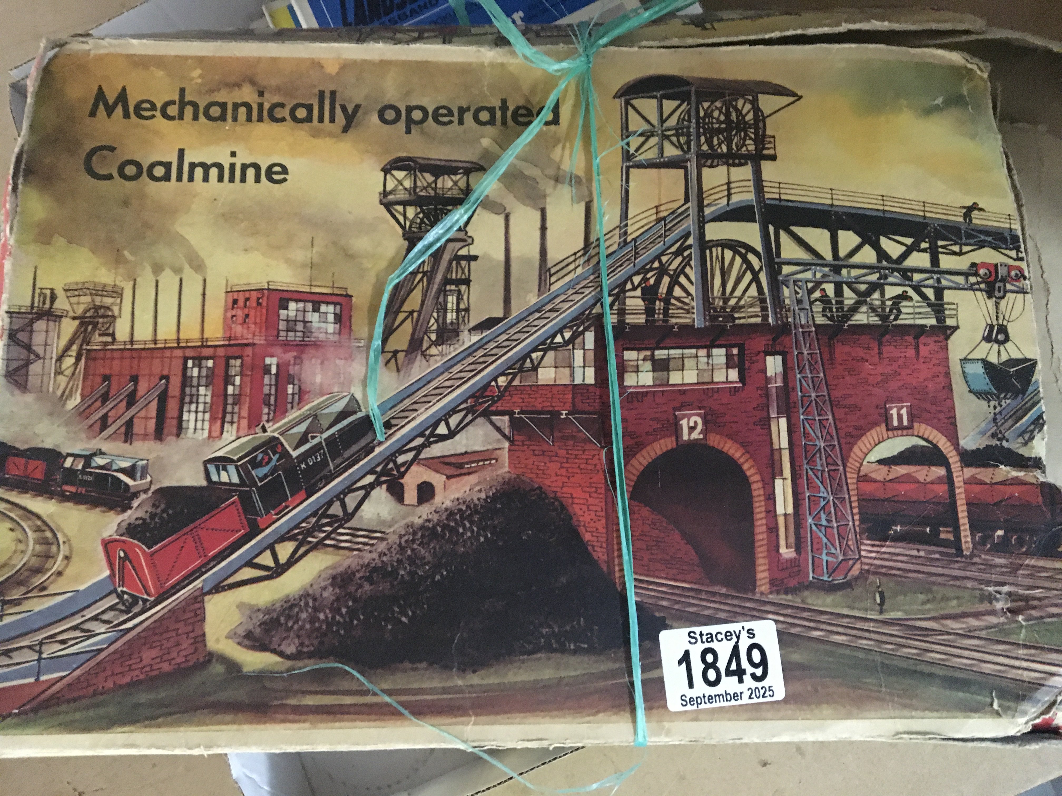 A boxed tin plate toy in the form of a coal mine .