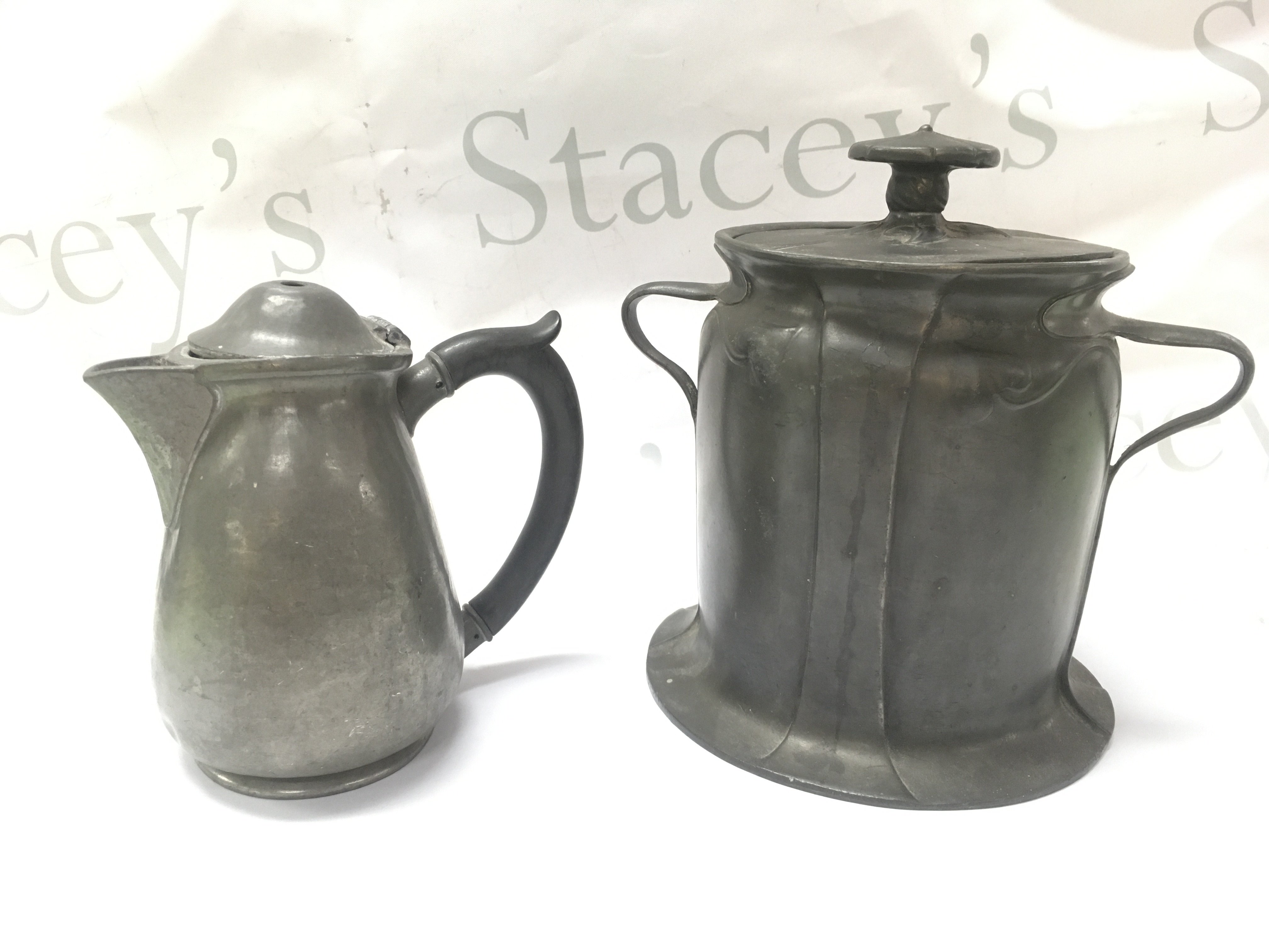 A Liberty Tudric Pewter biscuit barrel (Approx 18cm) and a damaged Tudric jug (14cm tall). Postage category C