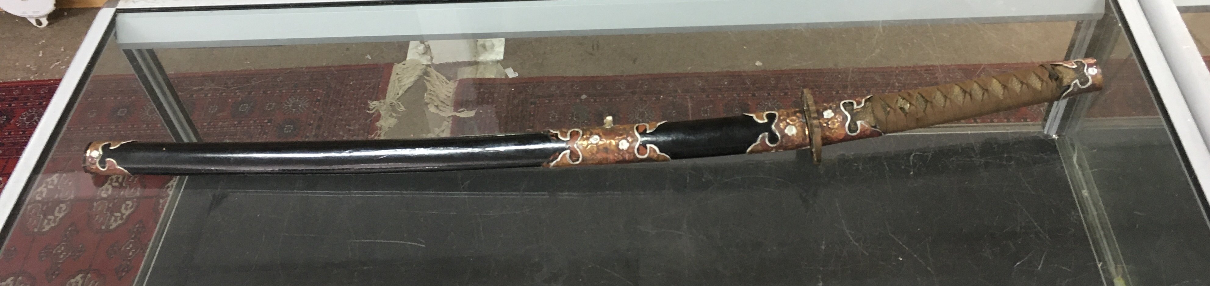 A Japanese Katana with later additional paintwork to the hilt and scabbard copper decoration . 103cm total length blade 72cm long approximately. This lot cannot be posted