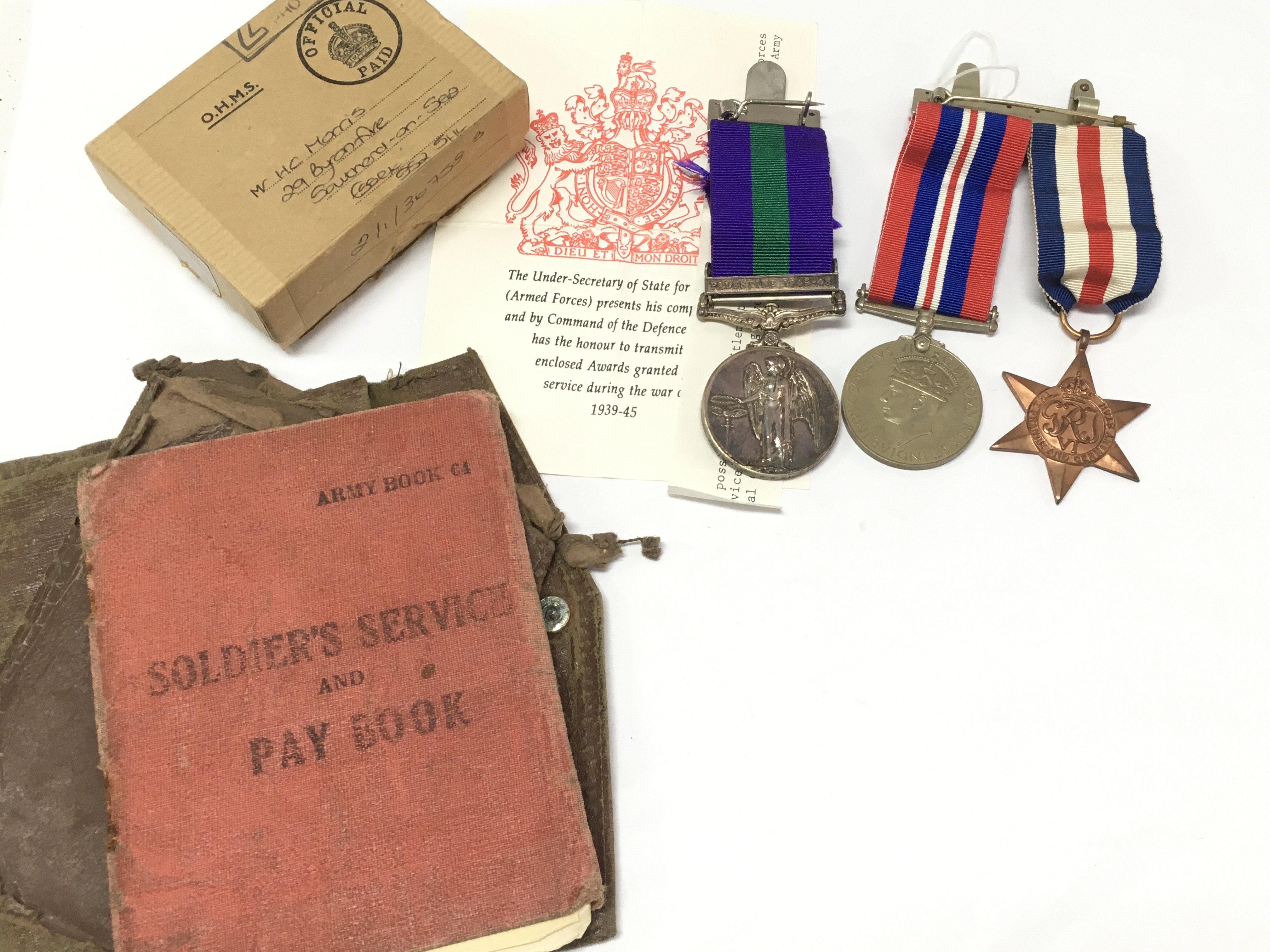 A GSM Palestine medal presented to 14730729 PTE.H.C.MORRIS OXF BUCKS, two WW2 medals and soldiers pay book. Postage category B