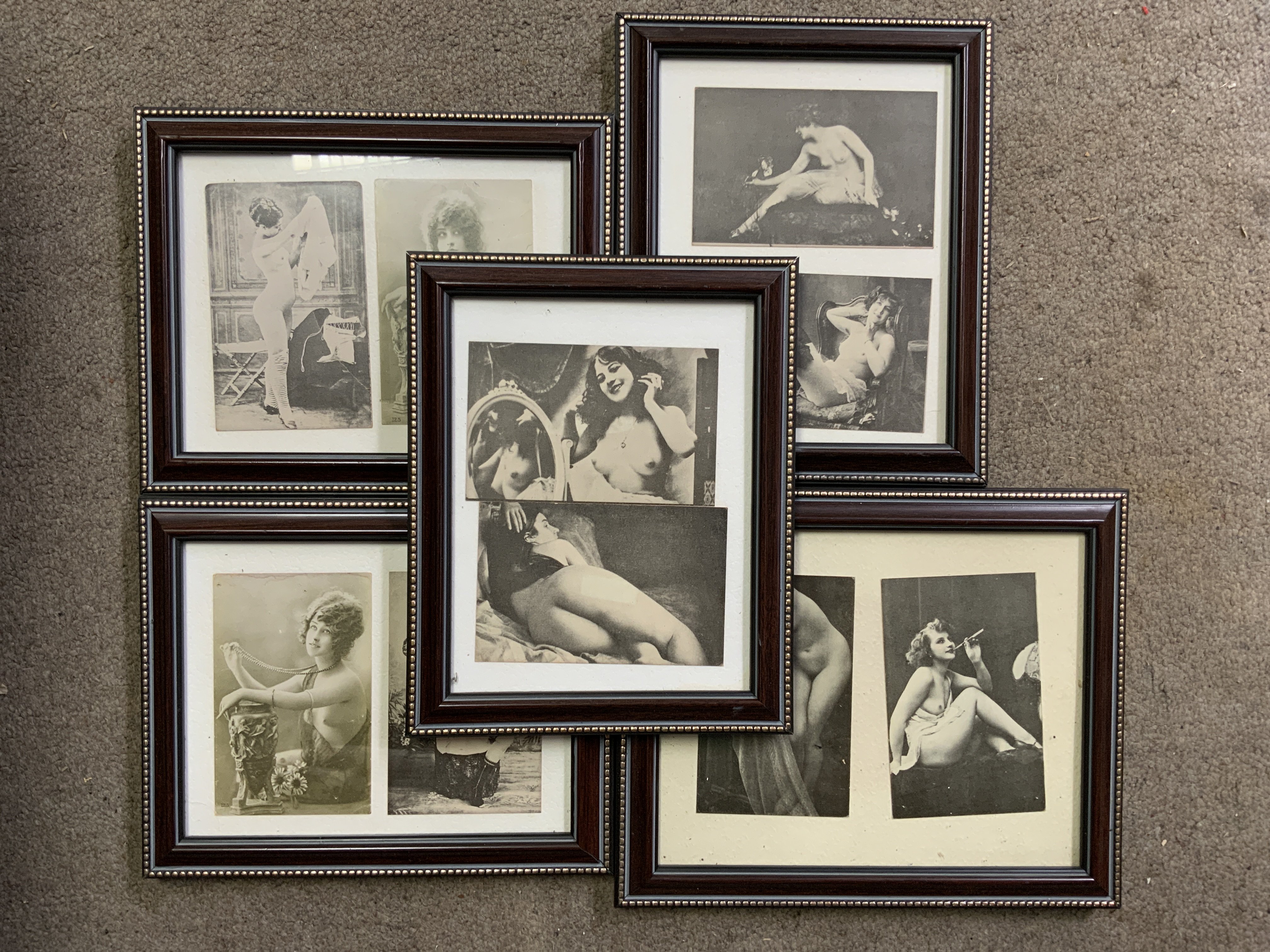 A collection of framed nude subject postcards.