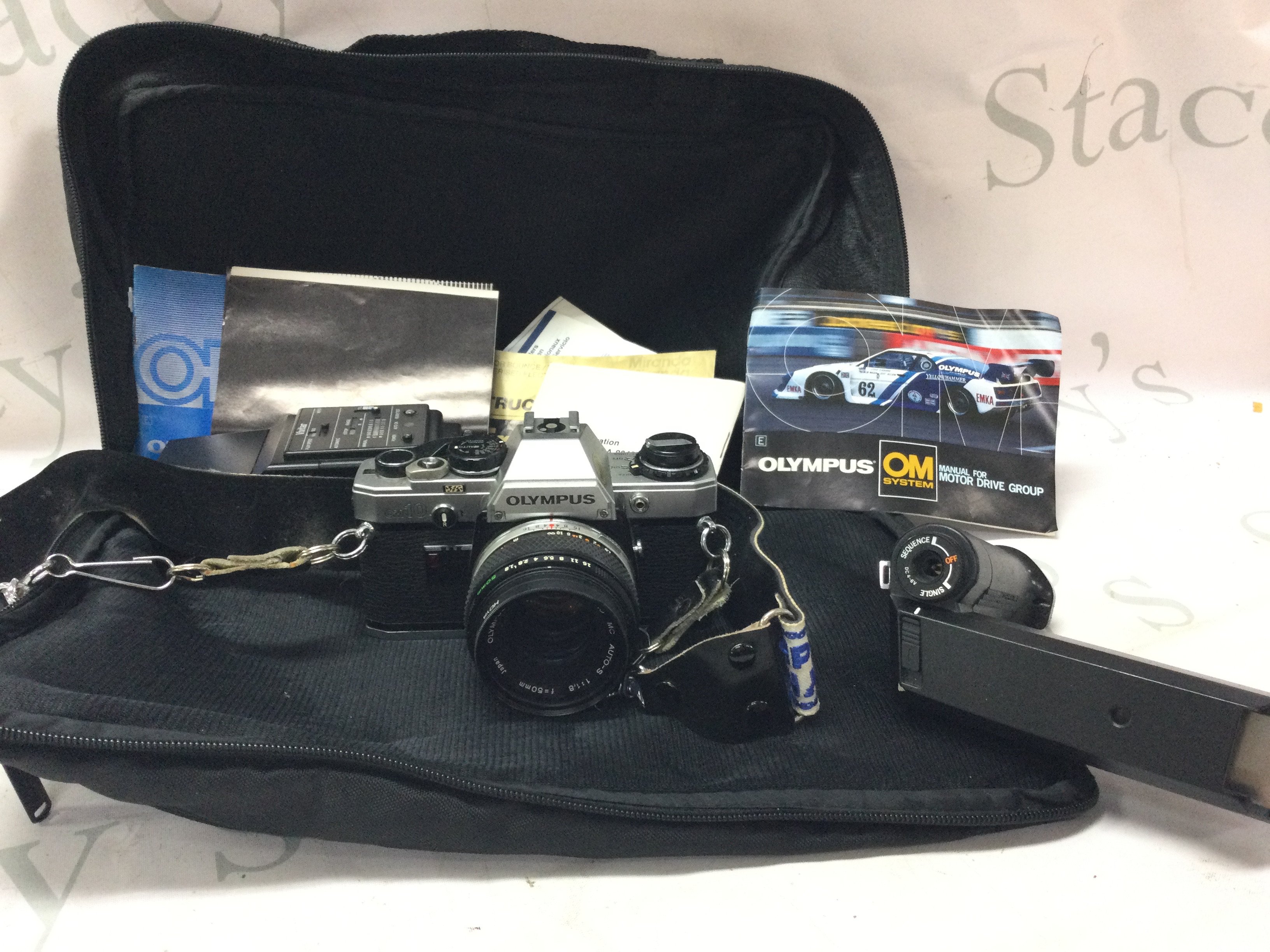 A vintage Olympus OM10 camera with accessories . Postage category B