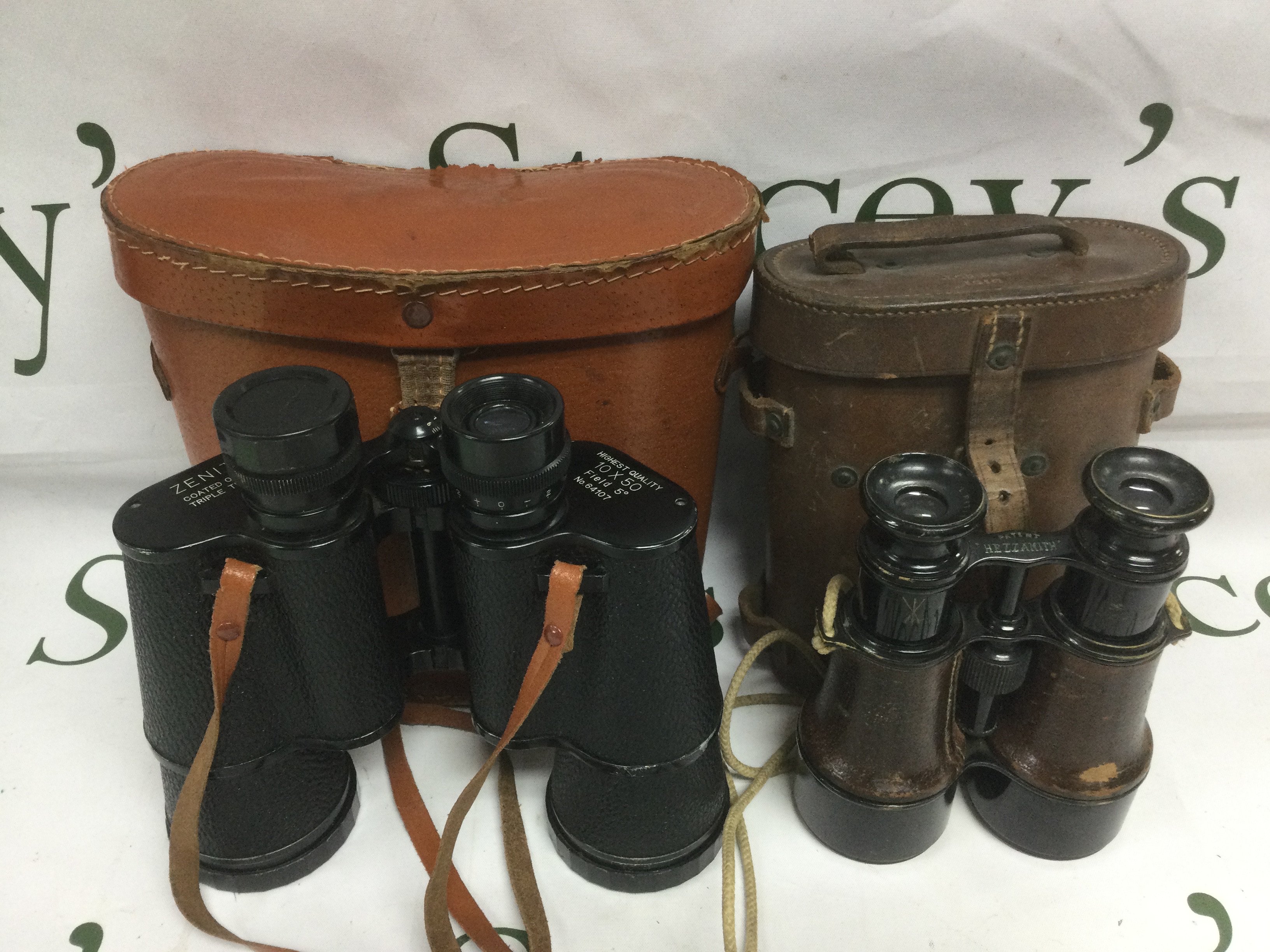 Two pairs of binoculars comprising an early 20th Century Hezzanith example and a later Zenith model (2). Shipping category D.