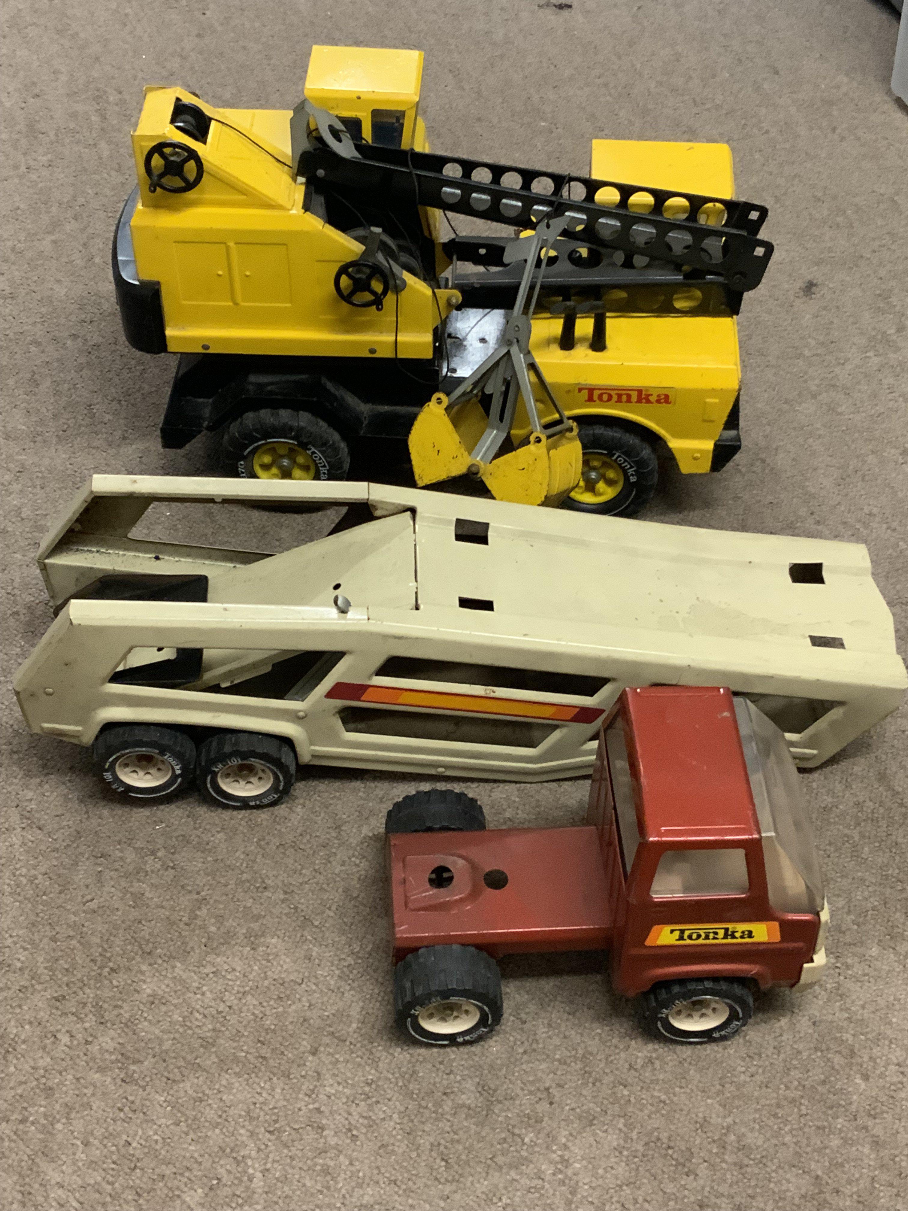 A vintage Tonka grab lorry together with a Toy tractor and car trailer.