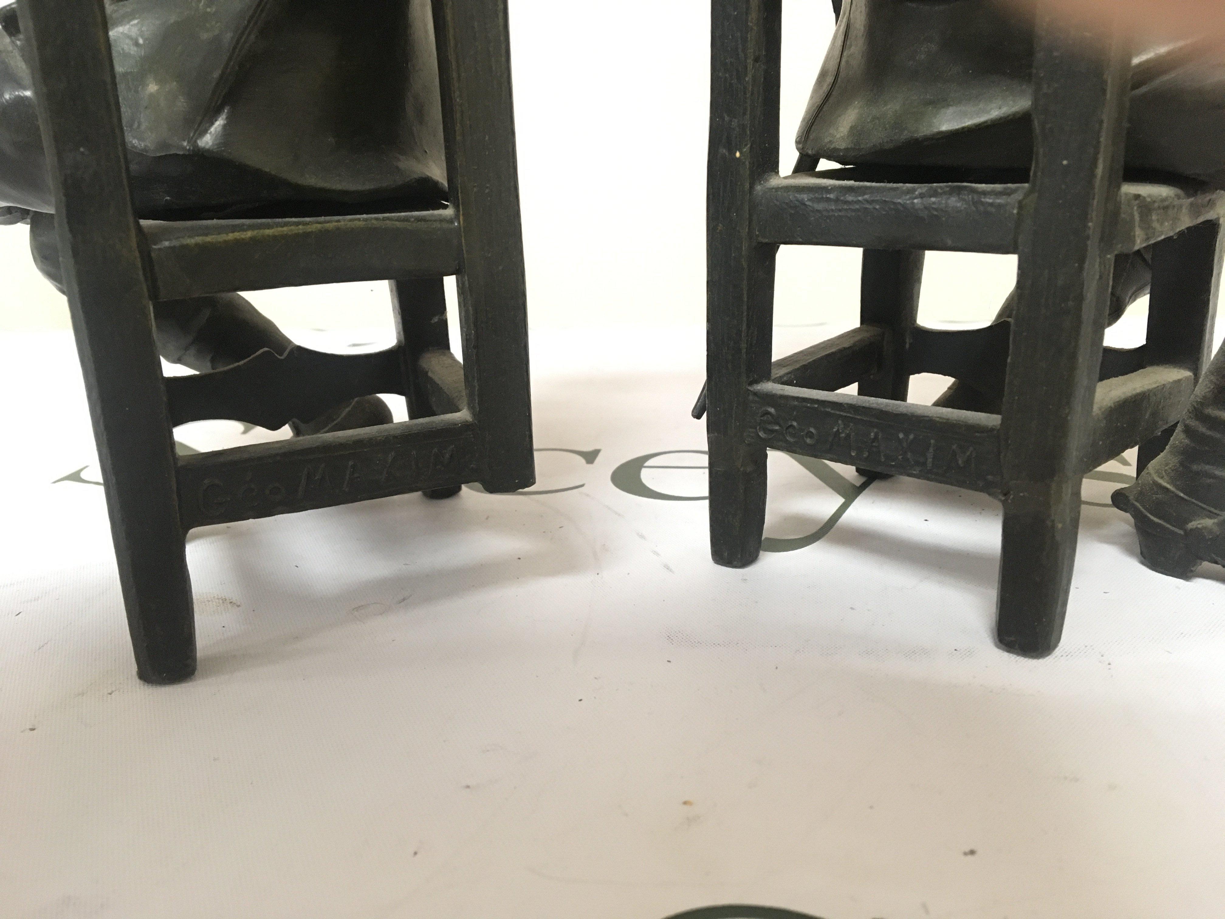 A pair of bronzed metal figures of seated cavaliers the chair rail stamped Geo Maxim (2) Height 26cm one leg damaged.- NO RESERVE