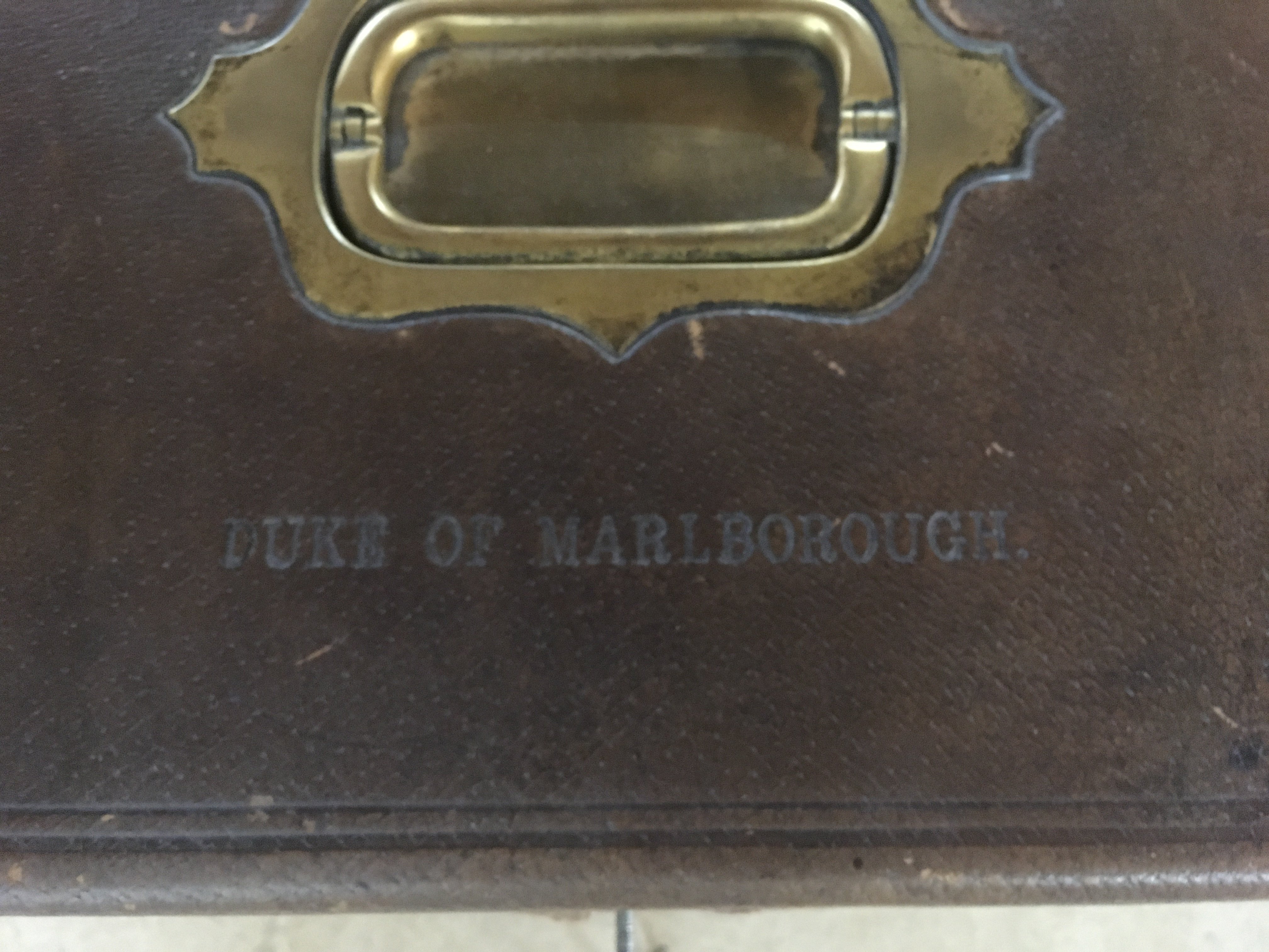 A Churchill family leather and brass cigar box the hinge lid impressed With The Duke of Marlborough inset with a detector action Chubb lock .