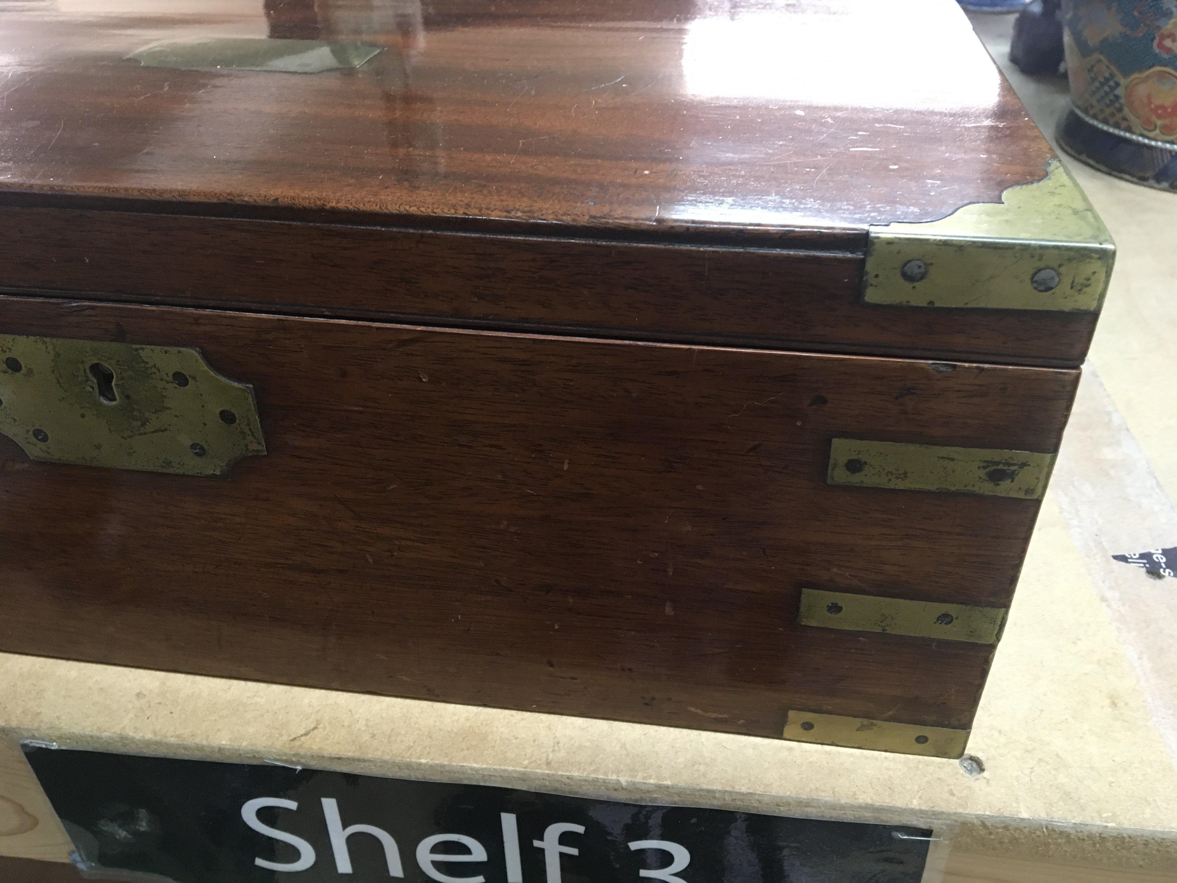 A Mahogany campaign writing slope brass bound with a fitted interior.