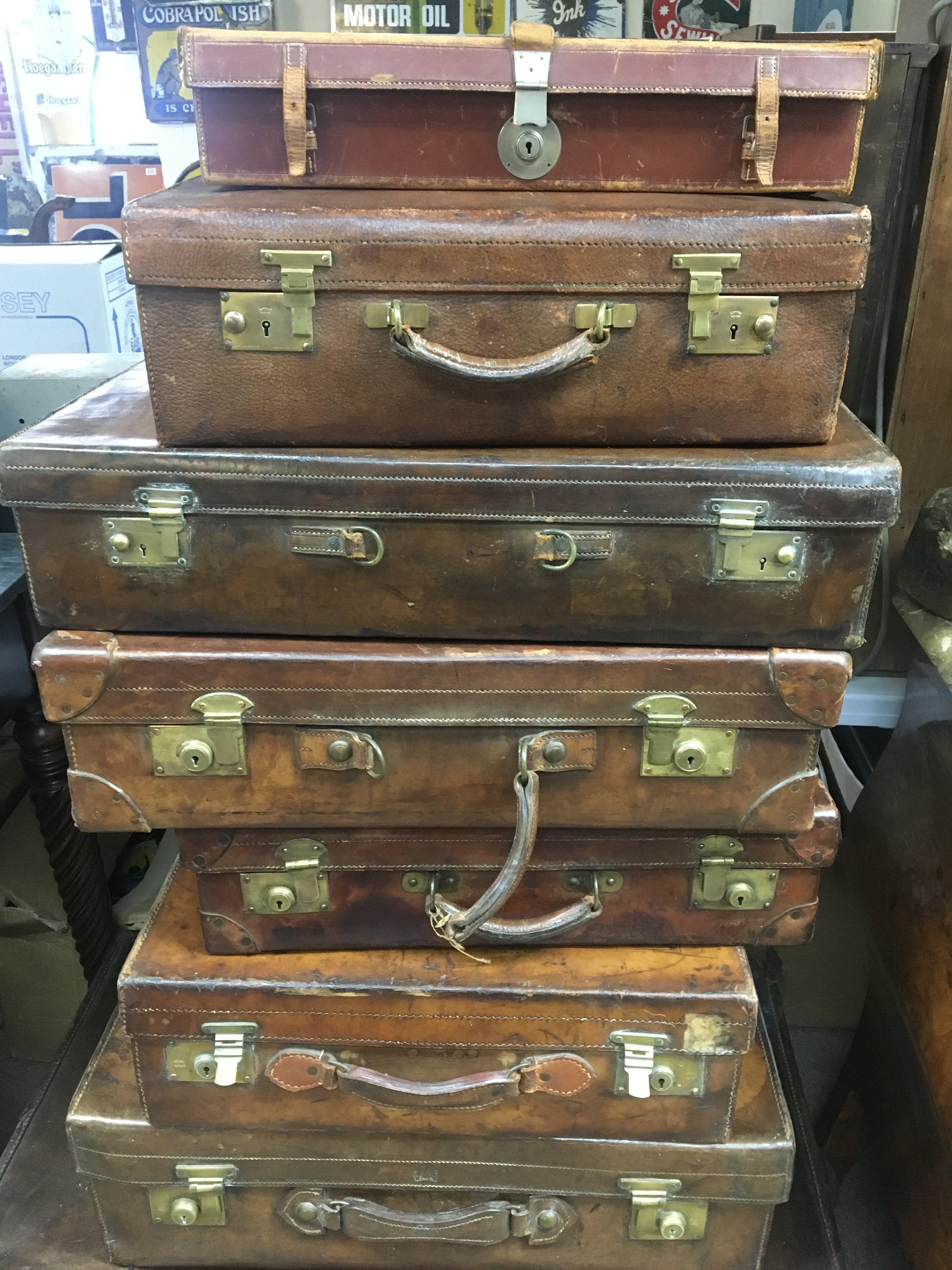 A collection of eleven vintage suite cases and traveling trunks .