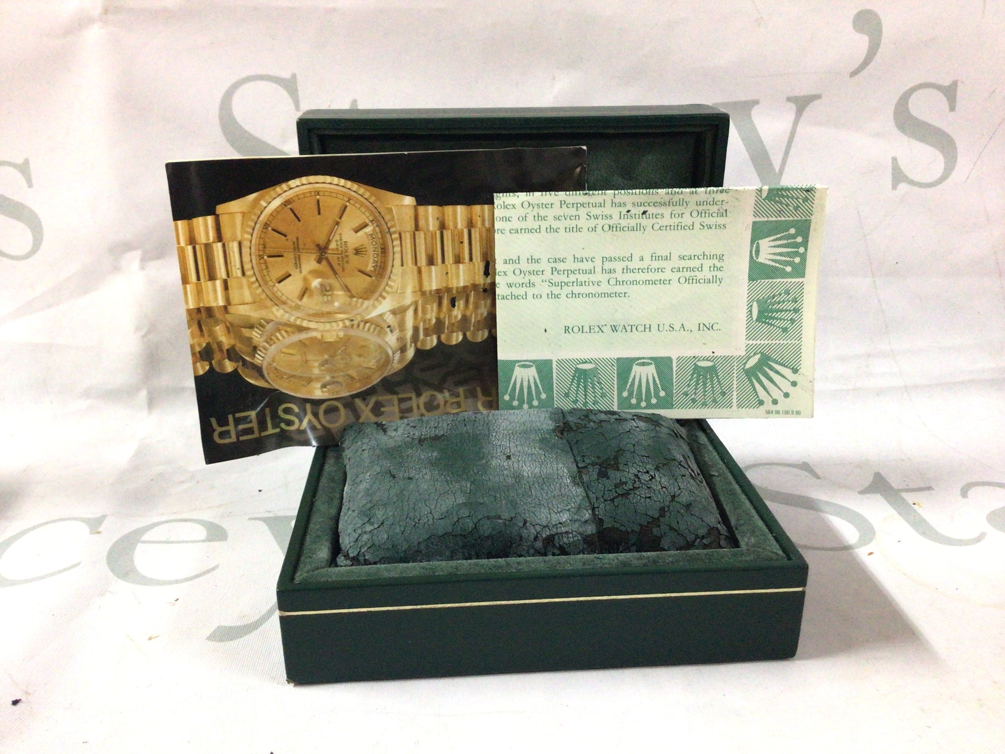 A vintage Rolex box with documents.