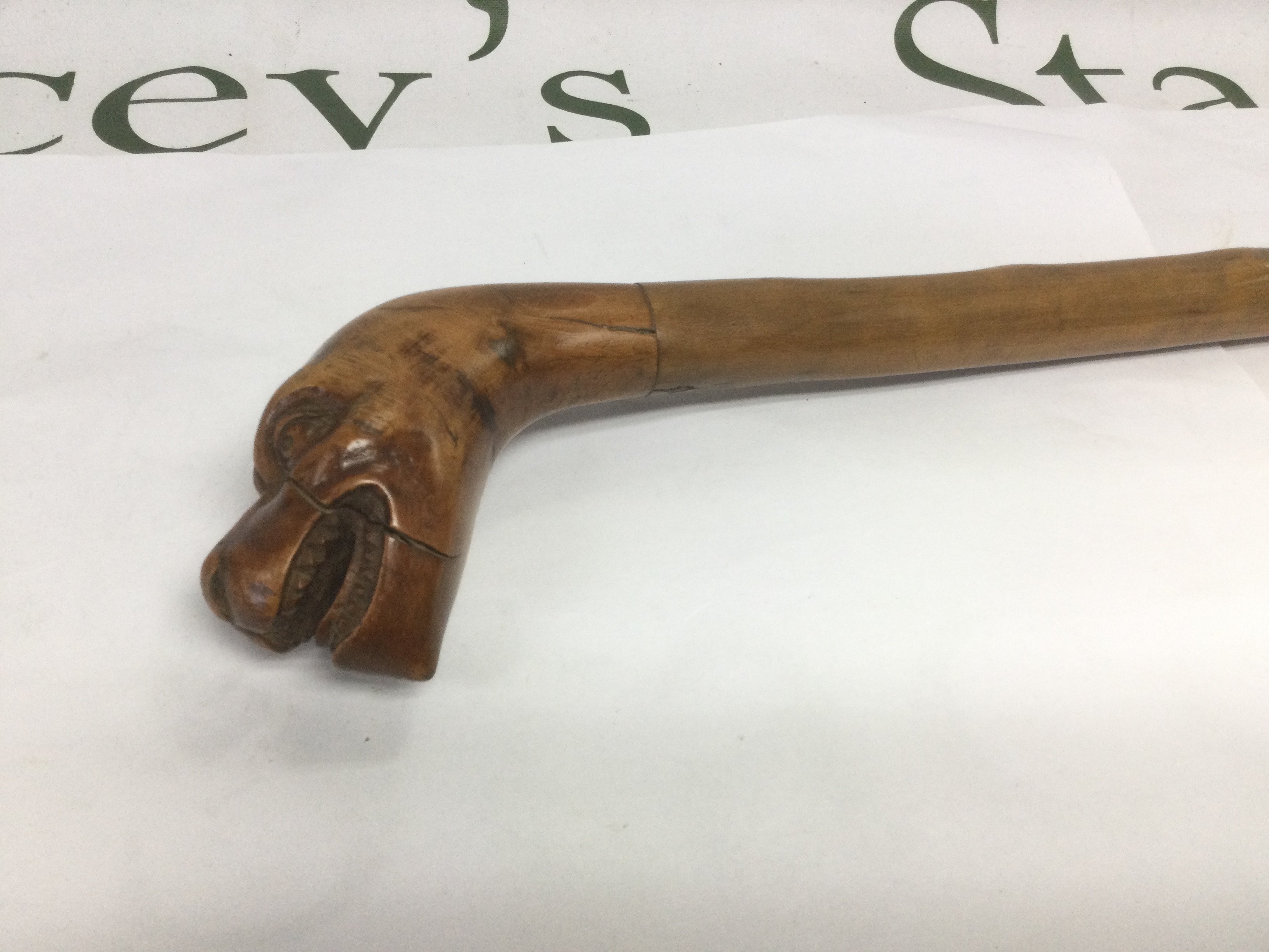 A walking cane, the handle in the form of the head of a mythical beast, approx total length 90cm. Shipping category D.