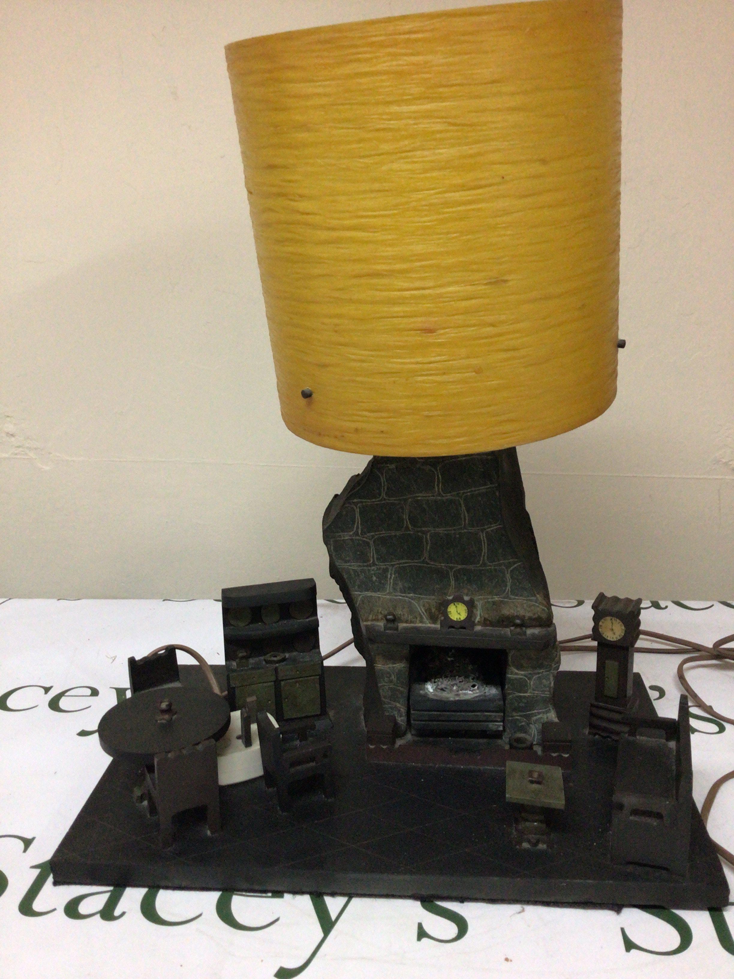 A Mid 20th Century welsh slate sculpture an interior scene with a fireplace and furniture the top with a lamp. Hight 43cm width 36cm