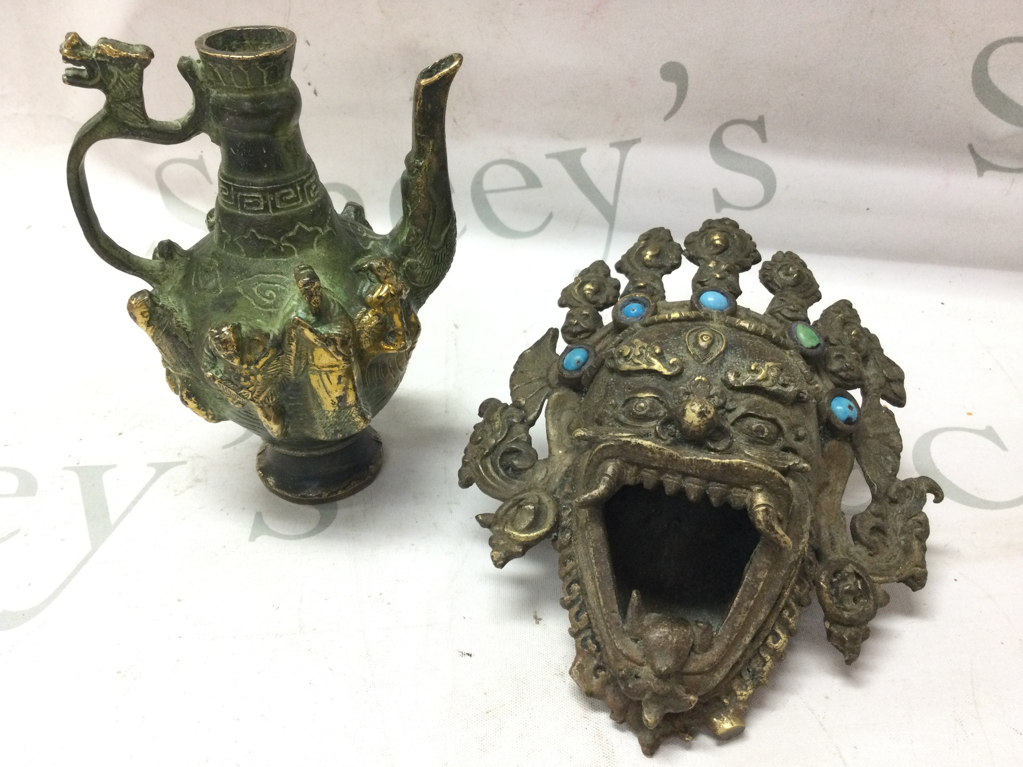 A Chinese bronze teapot (14cm tall) and a dragon mask (13cm wide) . Postage category B
