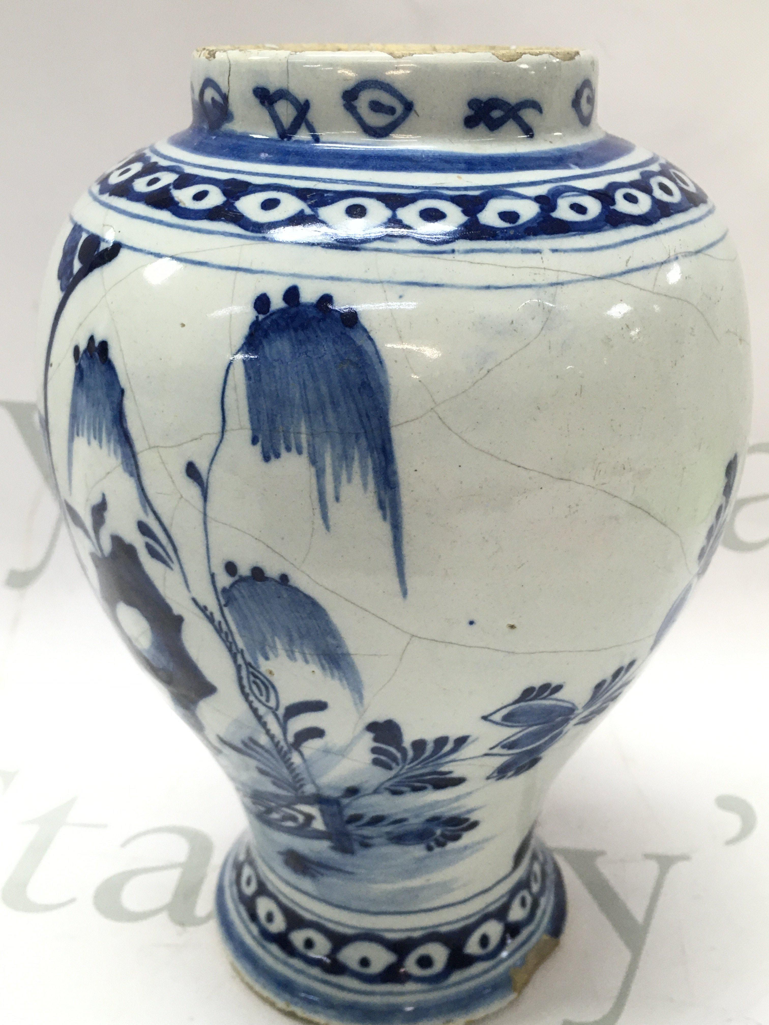 An 18th century Delft Dutch chinoiserie vase with river temple scene decoration , hairline crack damage and chips. 21cm tall approximately. This lot cannot be posted- NO RESERVE
