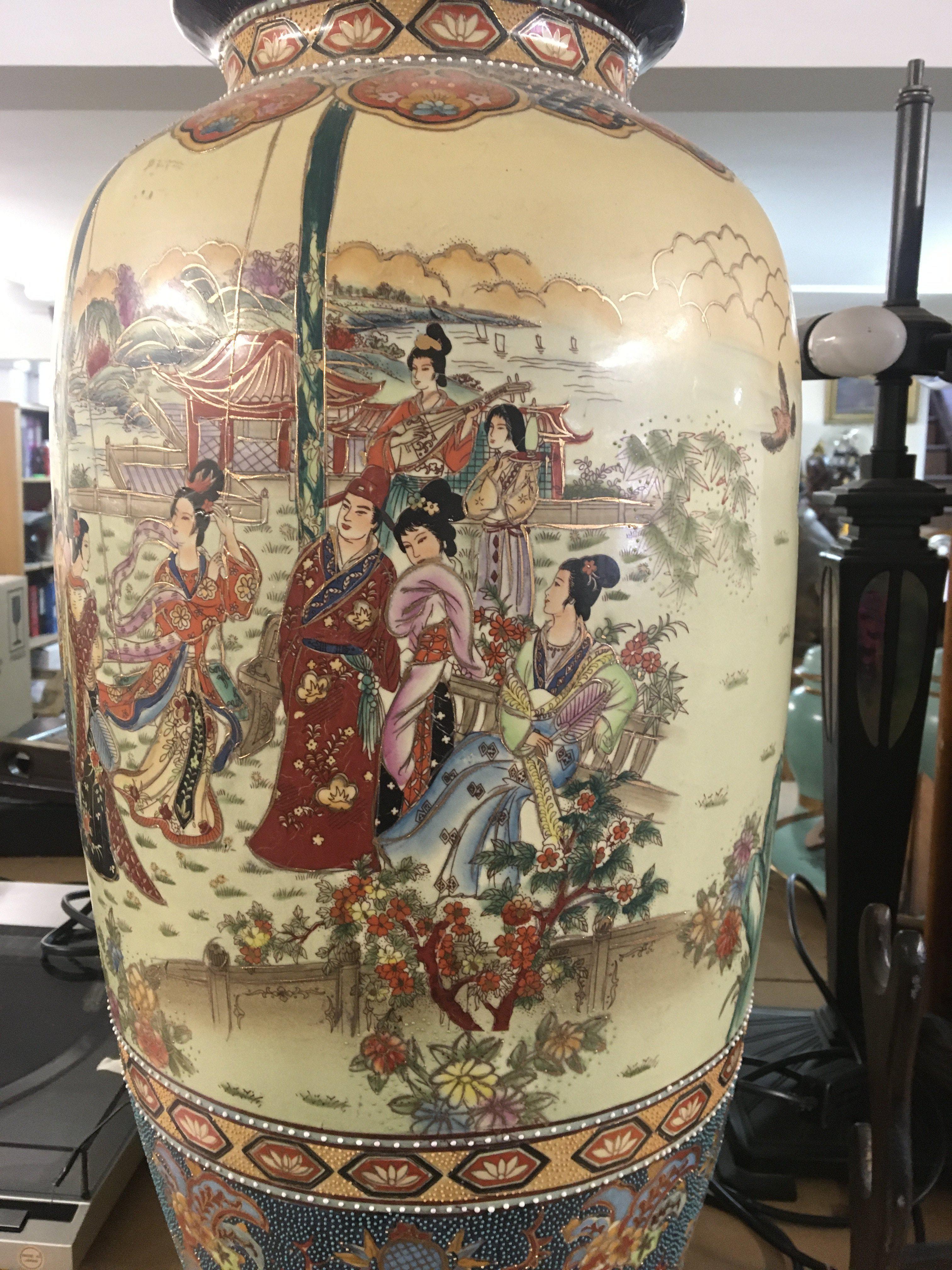 A large satsuma style vase decorated with figures in a landscape view .