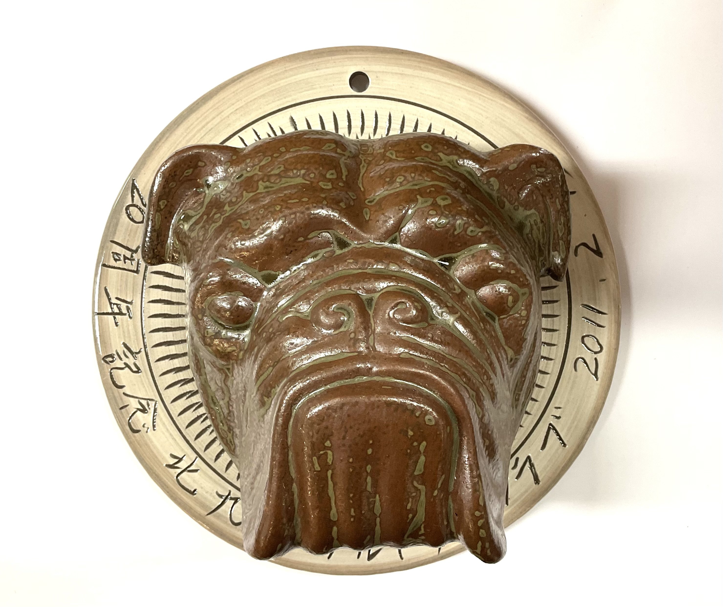 A Japanese studio pottery English Bulldog wall plaque, signed and dated. 23cm diameter.