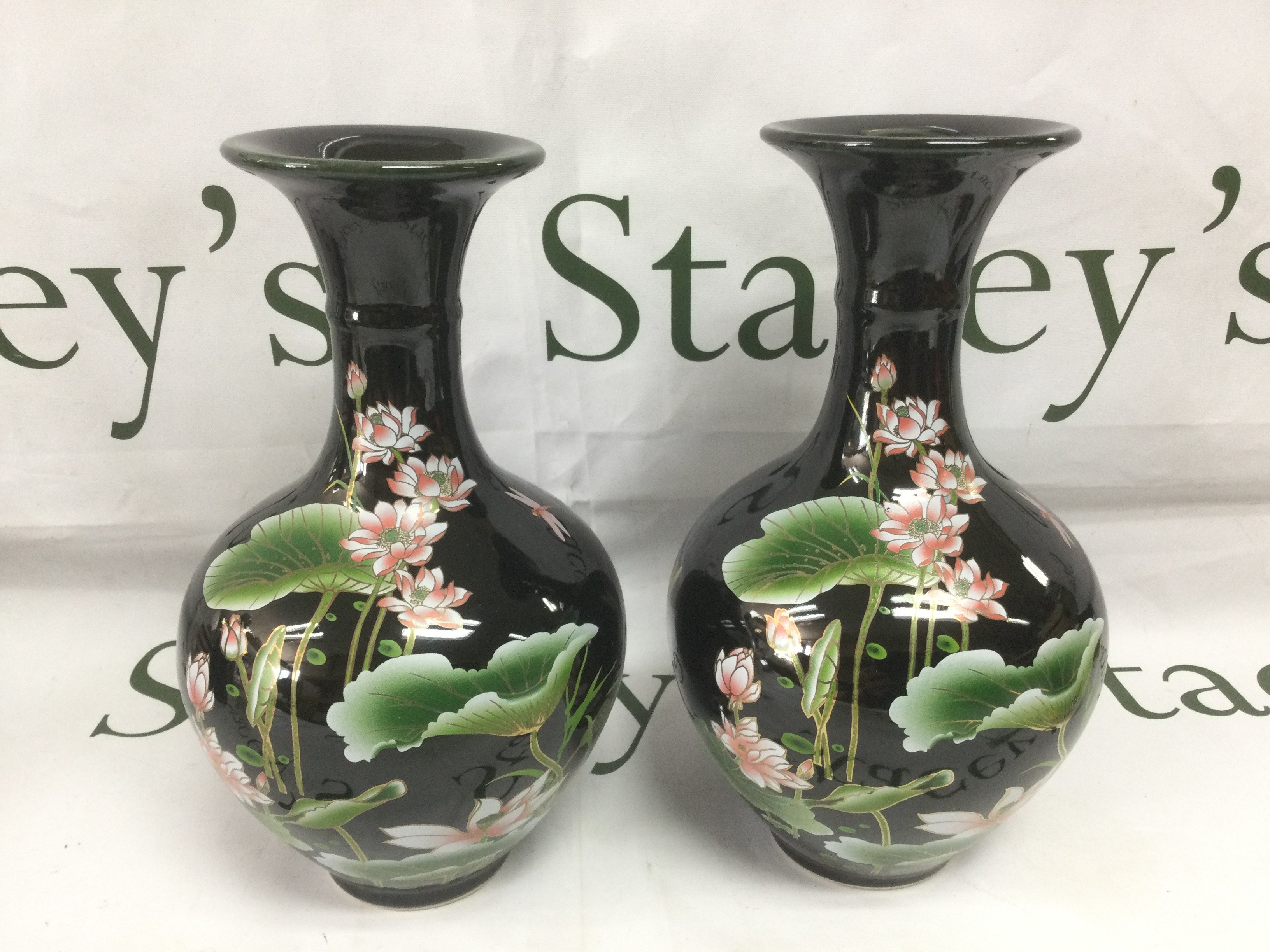 A pair of 20th Century export porcelain Chinese vases with floral decoration on a black ground, approx height 23.5cm. Shipping category D.