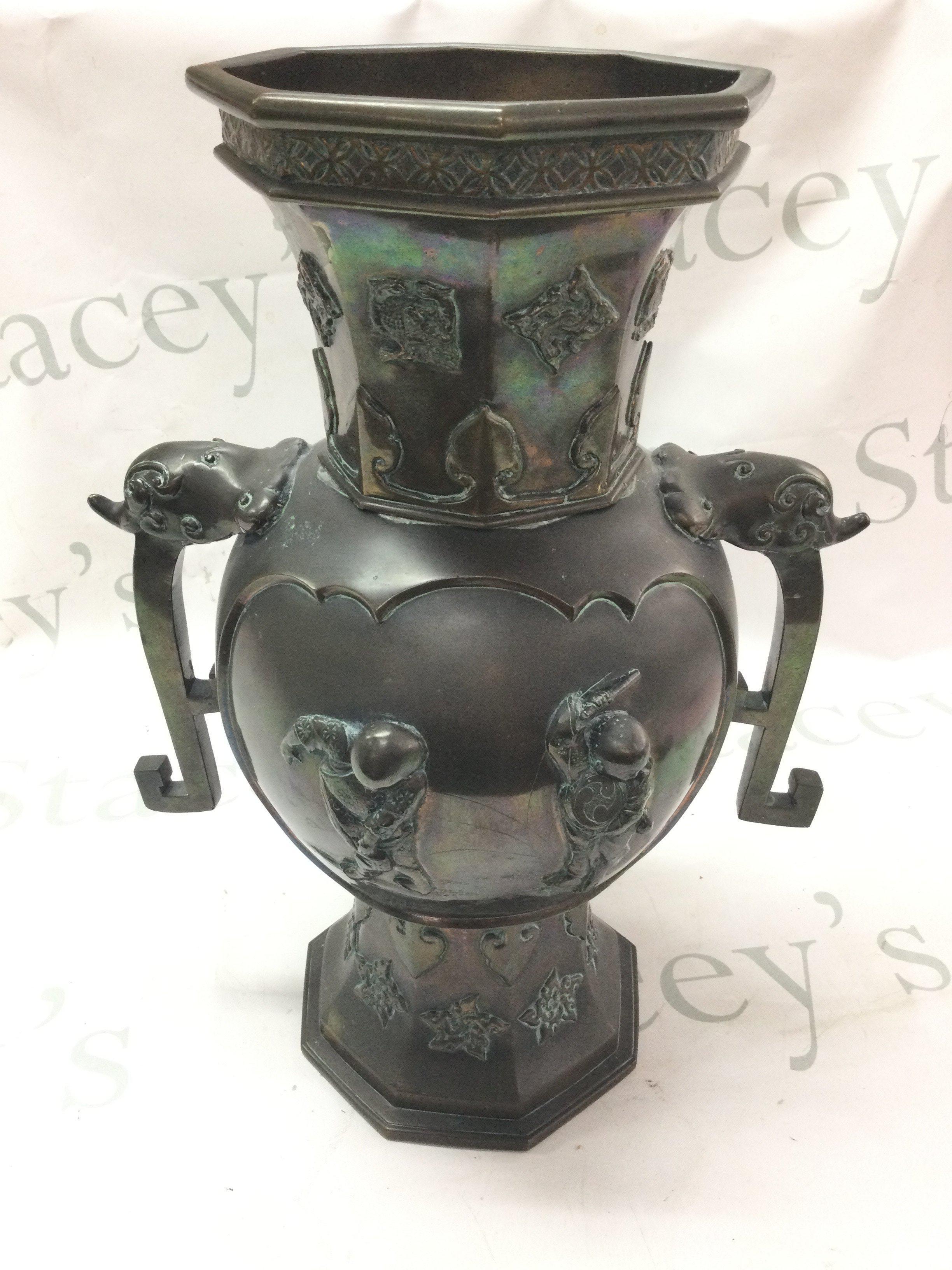 A Chinese twin handled bronze vase decorated with musician figures and figures at a lake scene, 37cm tall approximately. Postage category C