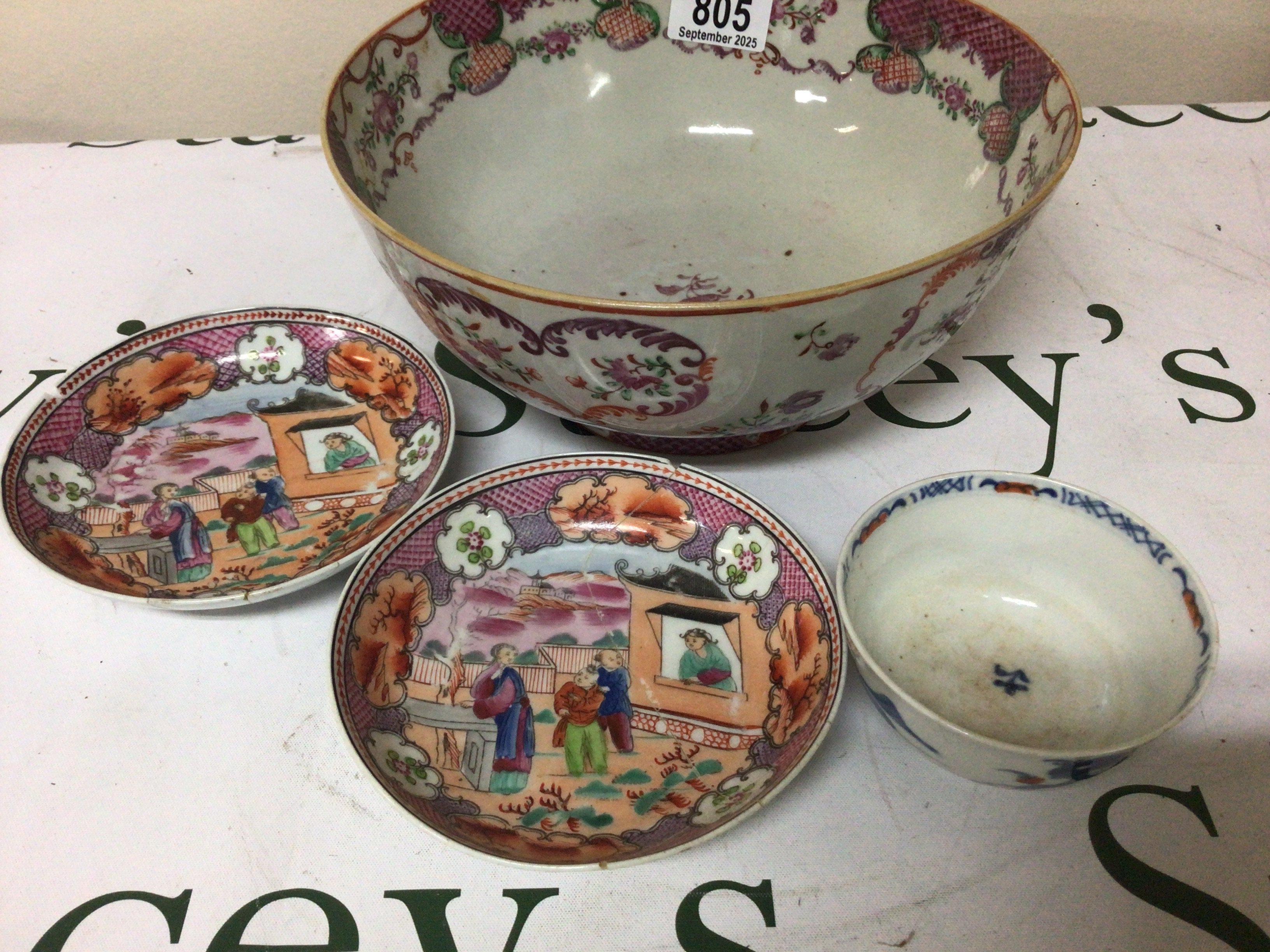 An 18th Century Chinese Export porcelain bowl painted with scrolls and foliage a pair of dishes decorated with figures and a tea bowl (some damage)