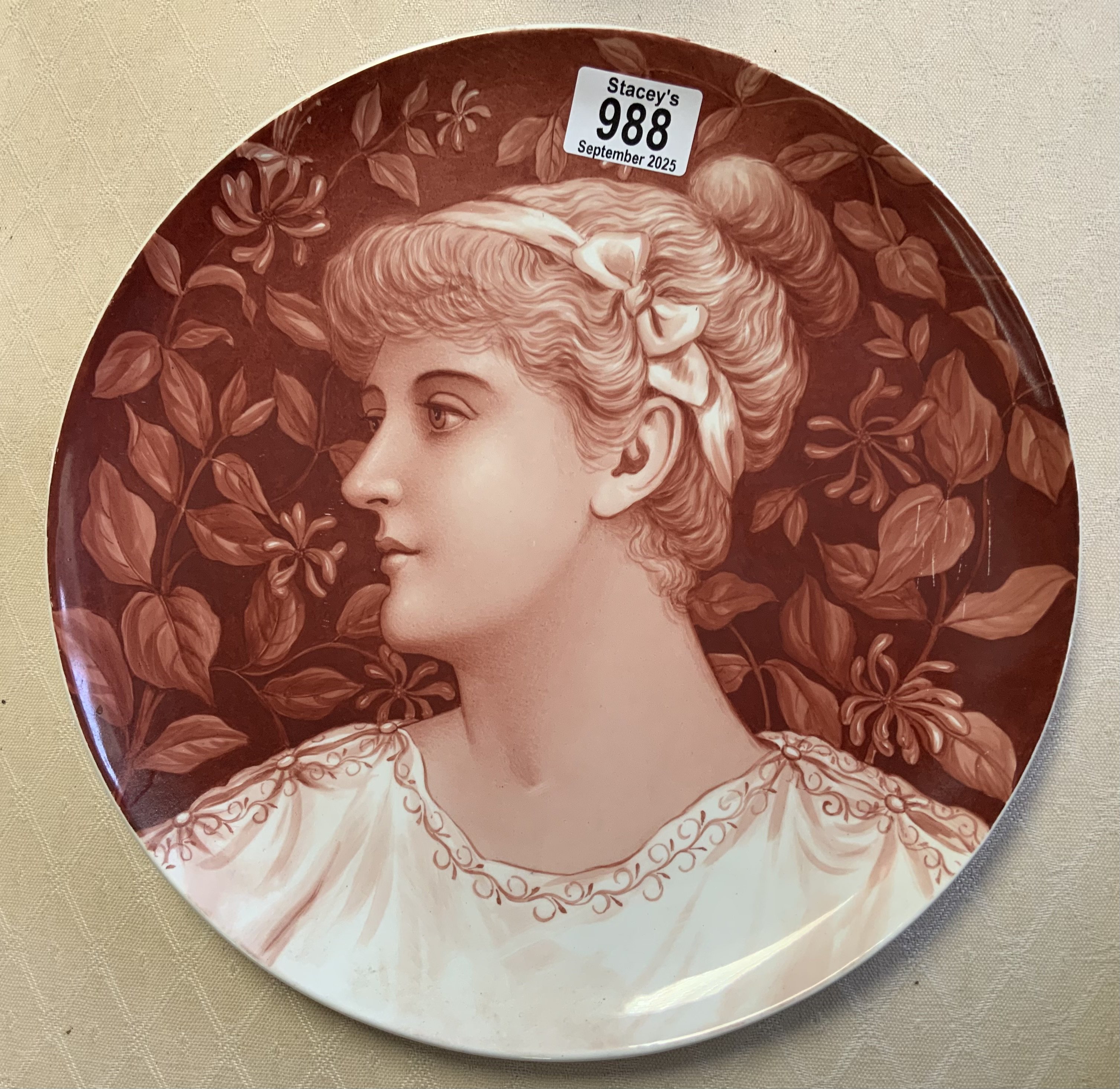 A ceramic wall charger with a hand painted pre-Raphaelite design of a lady. Impressed W to reverse. 30cm