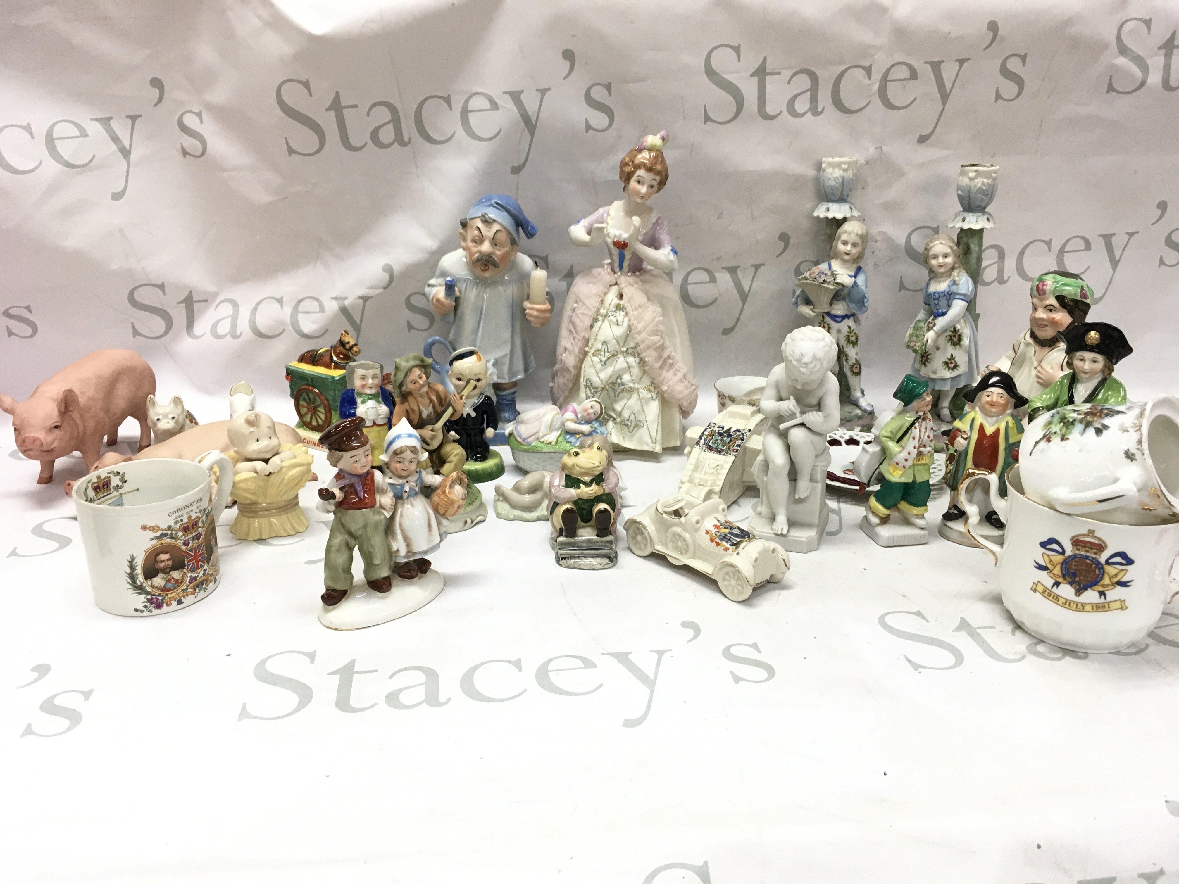 A collection of porcelain figures including German figures including a pair of couple candlestick figures, Southend on sea Carlton ware , GDR , Guinness Carltonware man with horse in cart. This lot cannot be posted