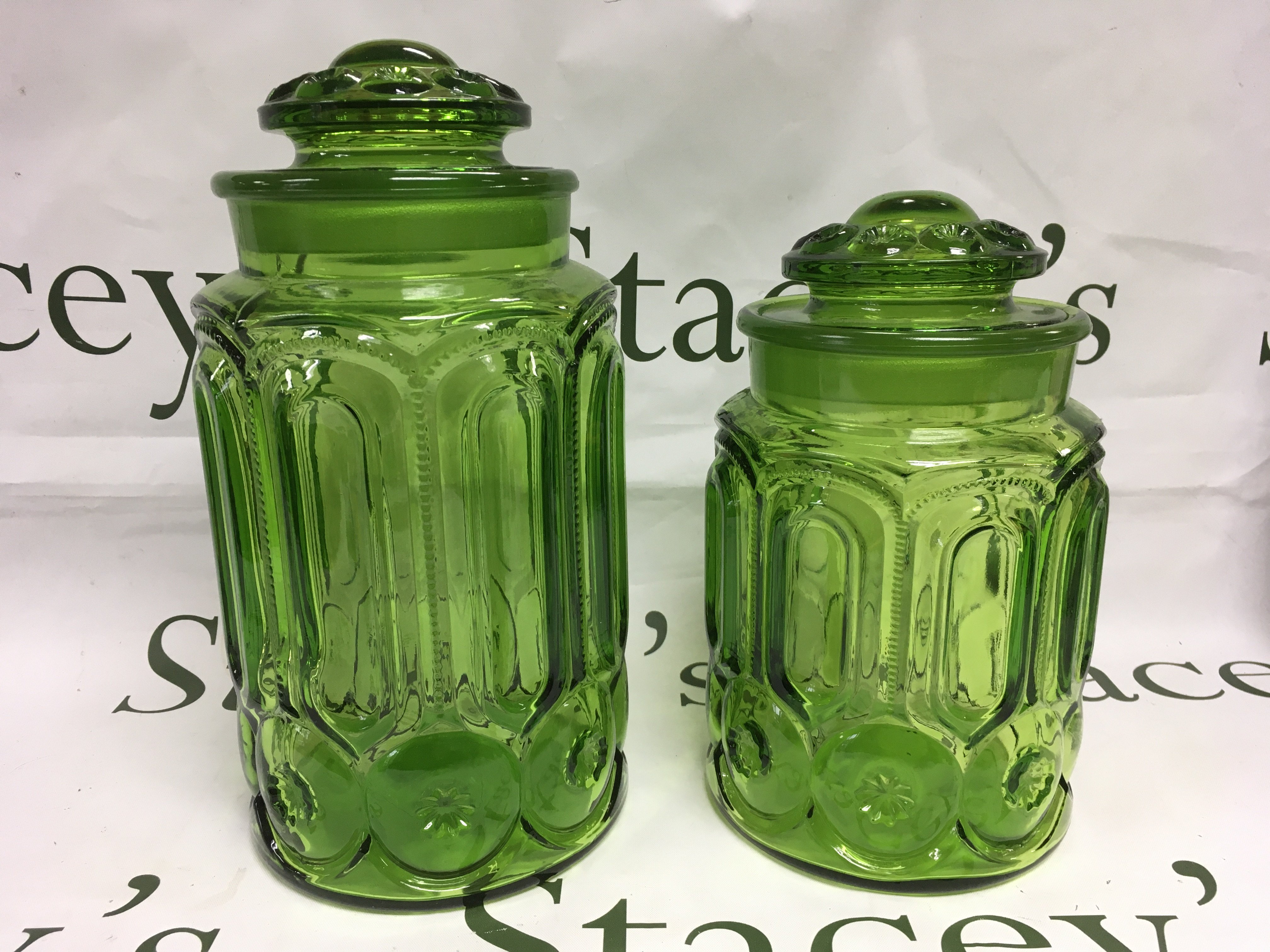 Two conforming garden glass jars and covers, approx heights 28cm and 23cm. Shipping category D.