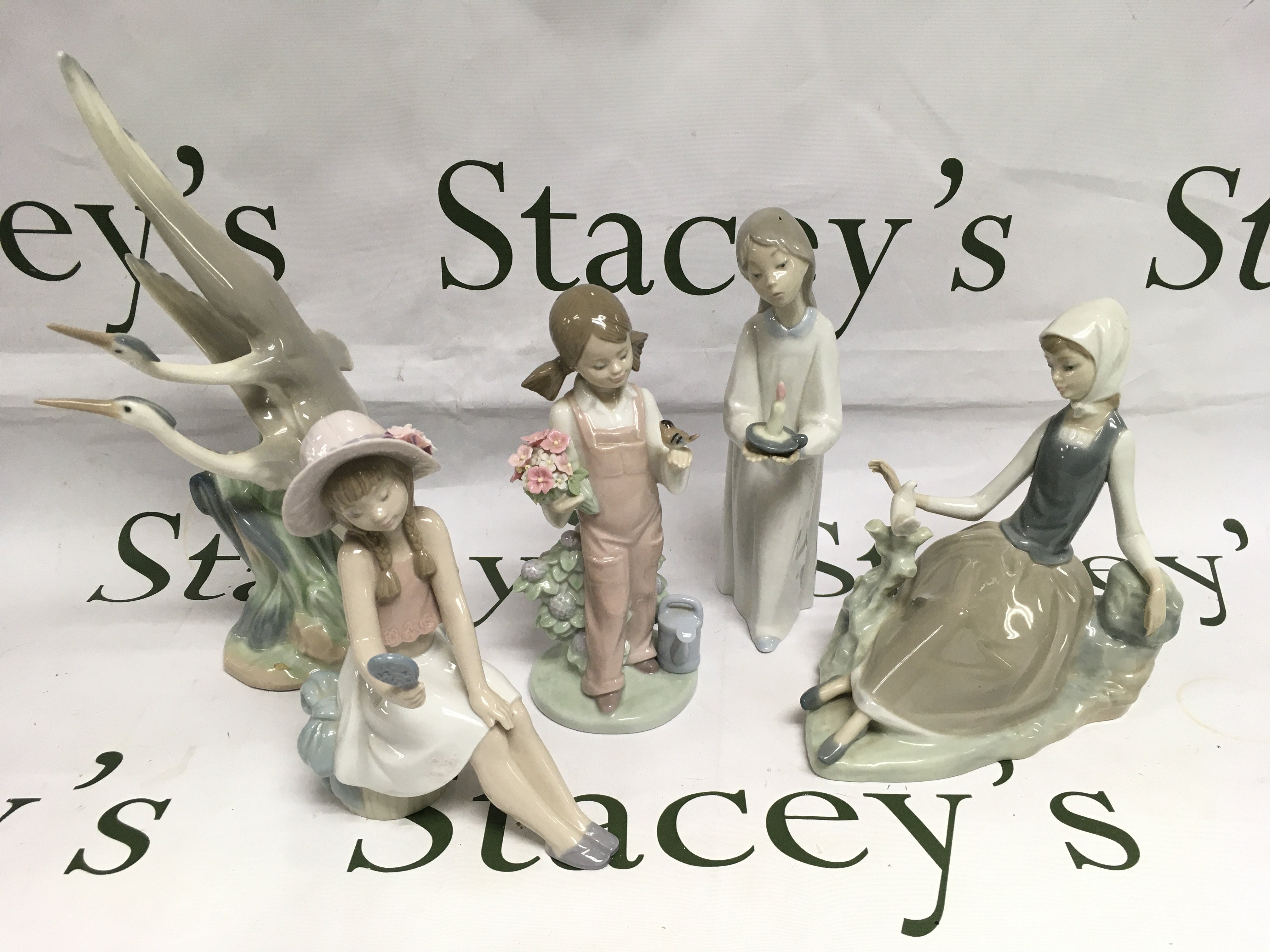 Four Lladro figures and one Nao, all boxed. Shipping category D.