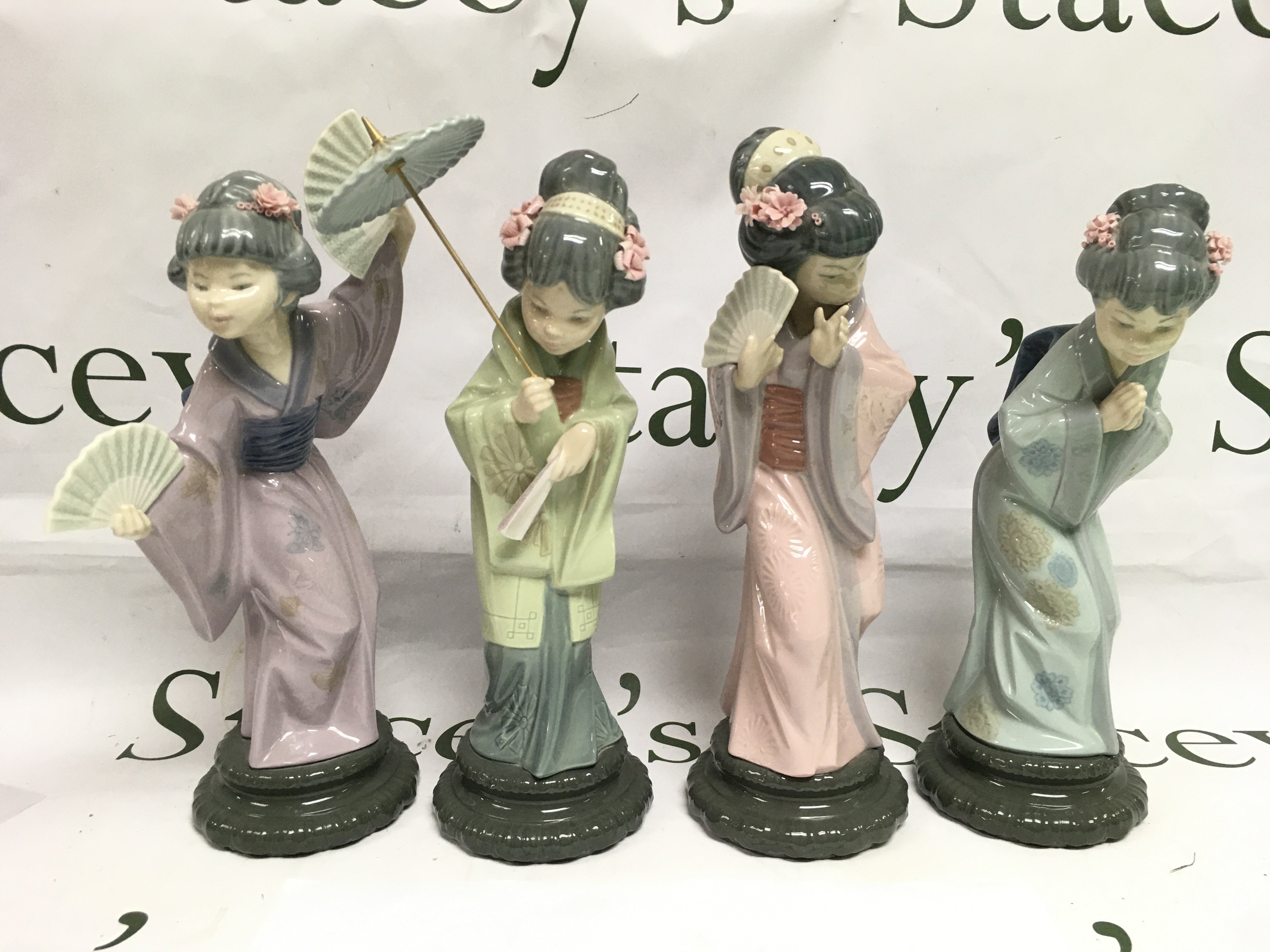 Four Lladro figures of geishas, approx height 29cm. Shipping category D.