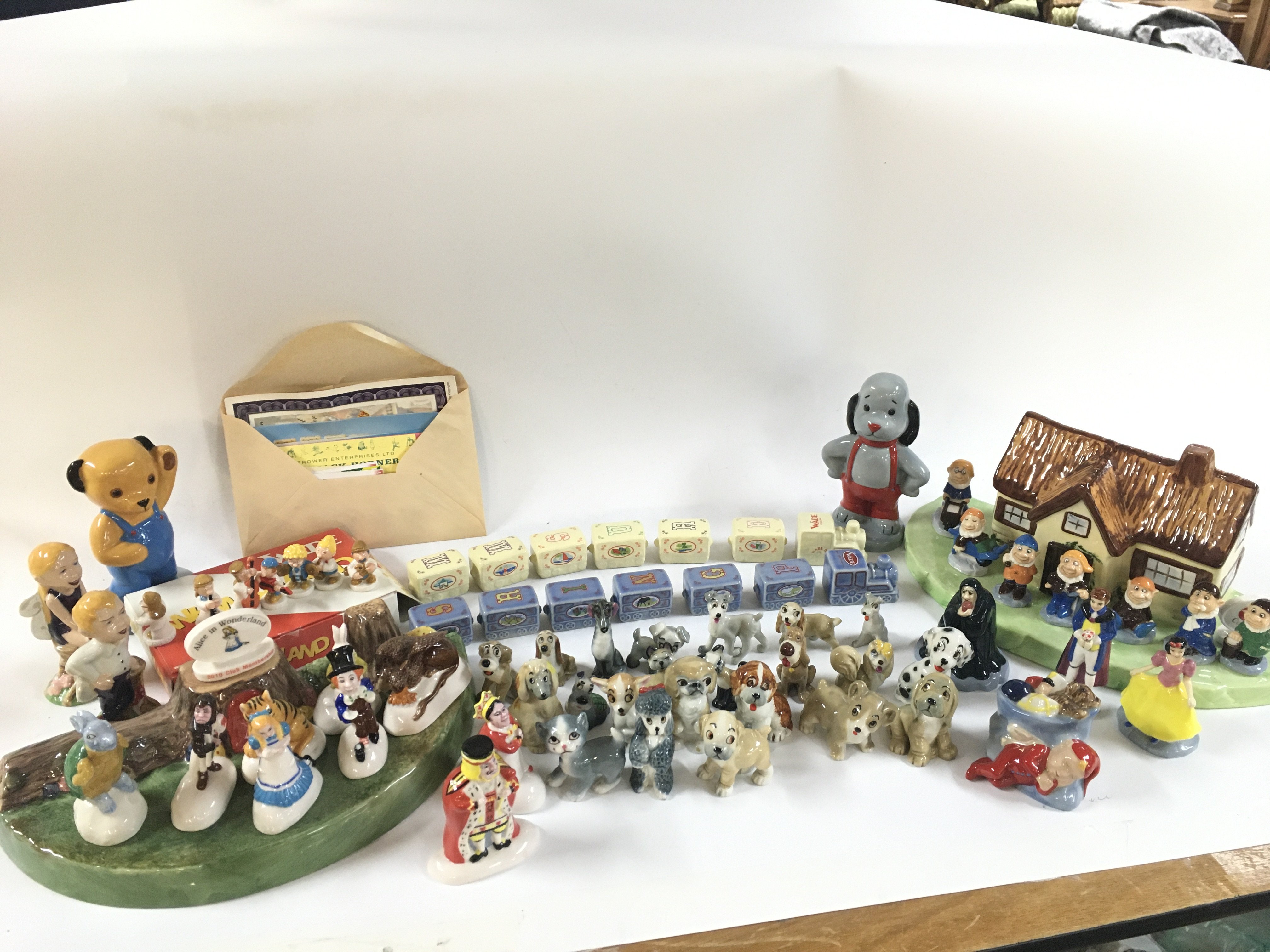 A collection of Wade porcelain figures including Alice In wonderland 2010 club membership set, Wade 2009 snow white set , sooty etc