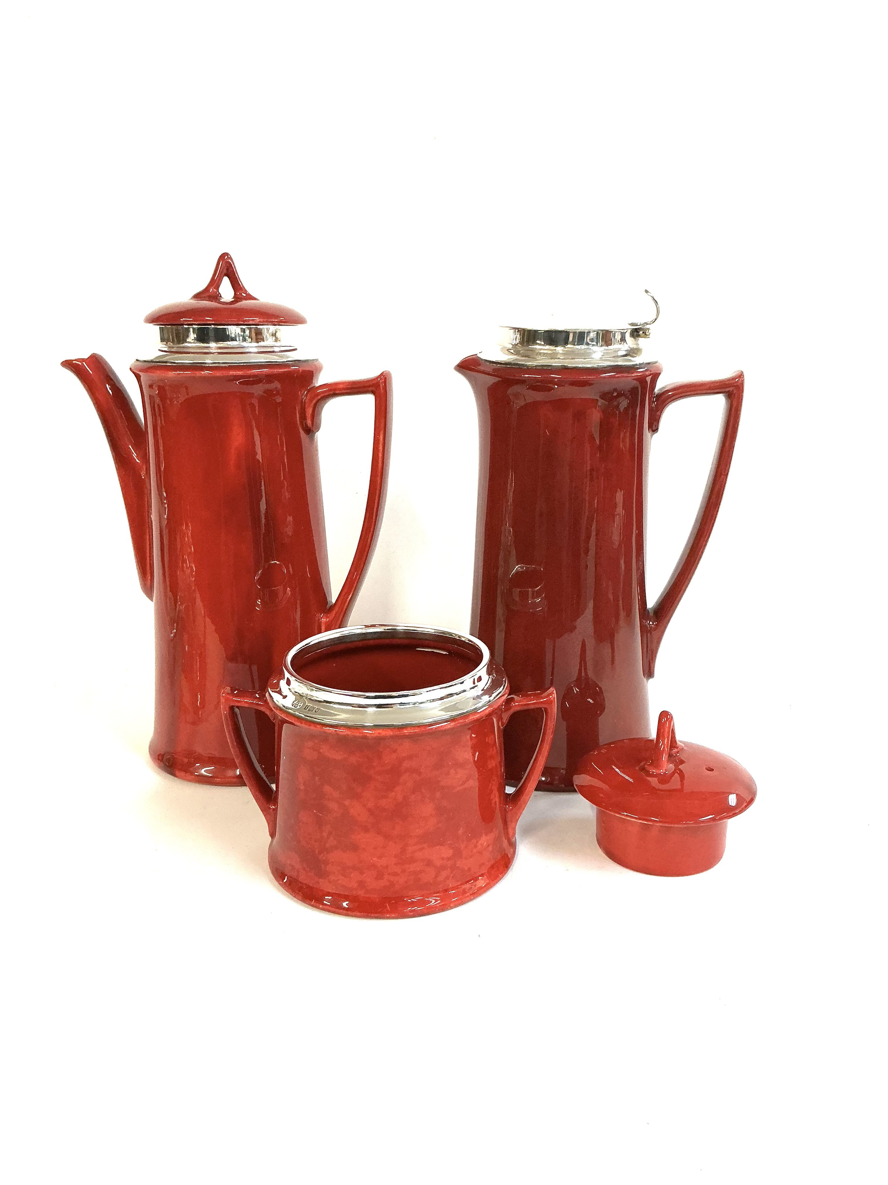 A silver mounted Royal Doulton Flambe Coffee pot, Water Jug, Sugar pot each with hallmarked silver rims.