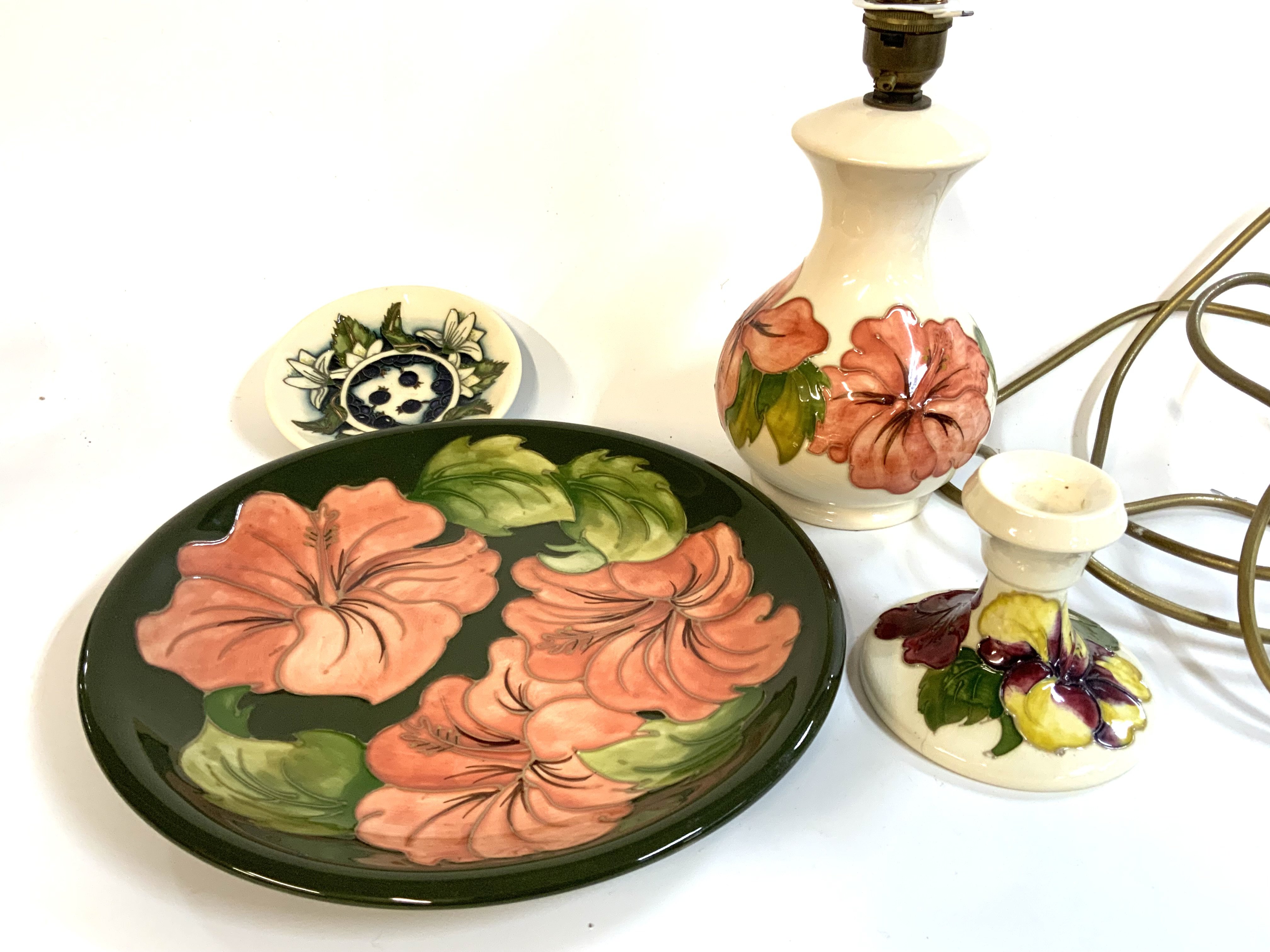 4 Moorcroft pottery items to include Hibiscus wall plate 26cm, Hibiscus design table lamp 18cm, Blackberry pin dish 12cm, Hibiscus candlestick (A/F).
