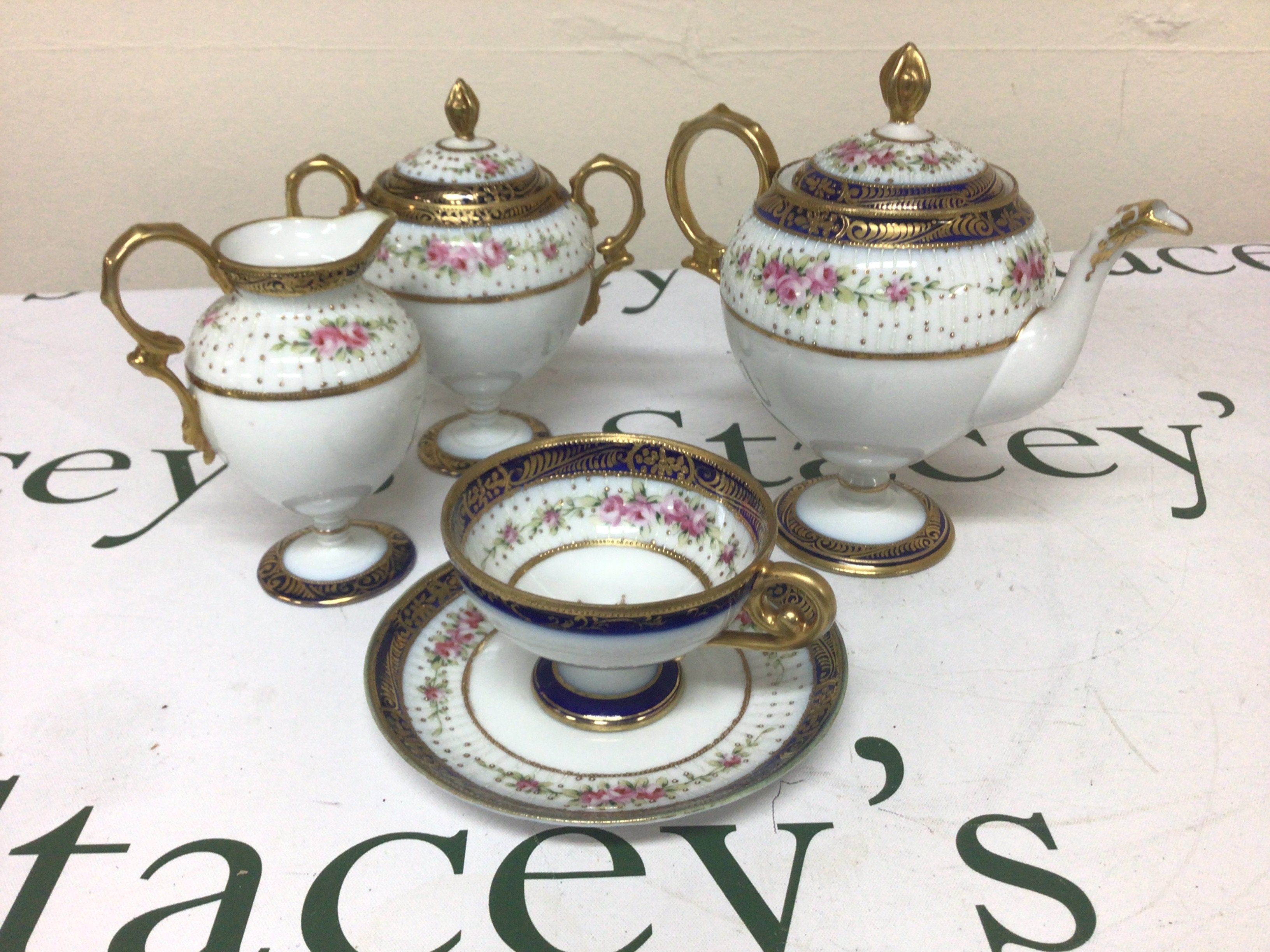 A Noritaki porcelain Bachelor tea set decorated with flowers and applied gilt no obvious damage.