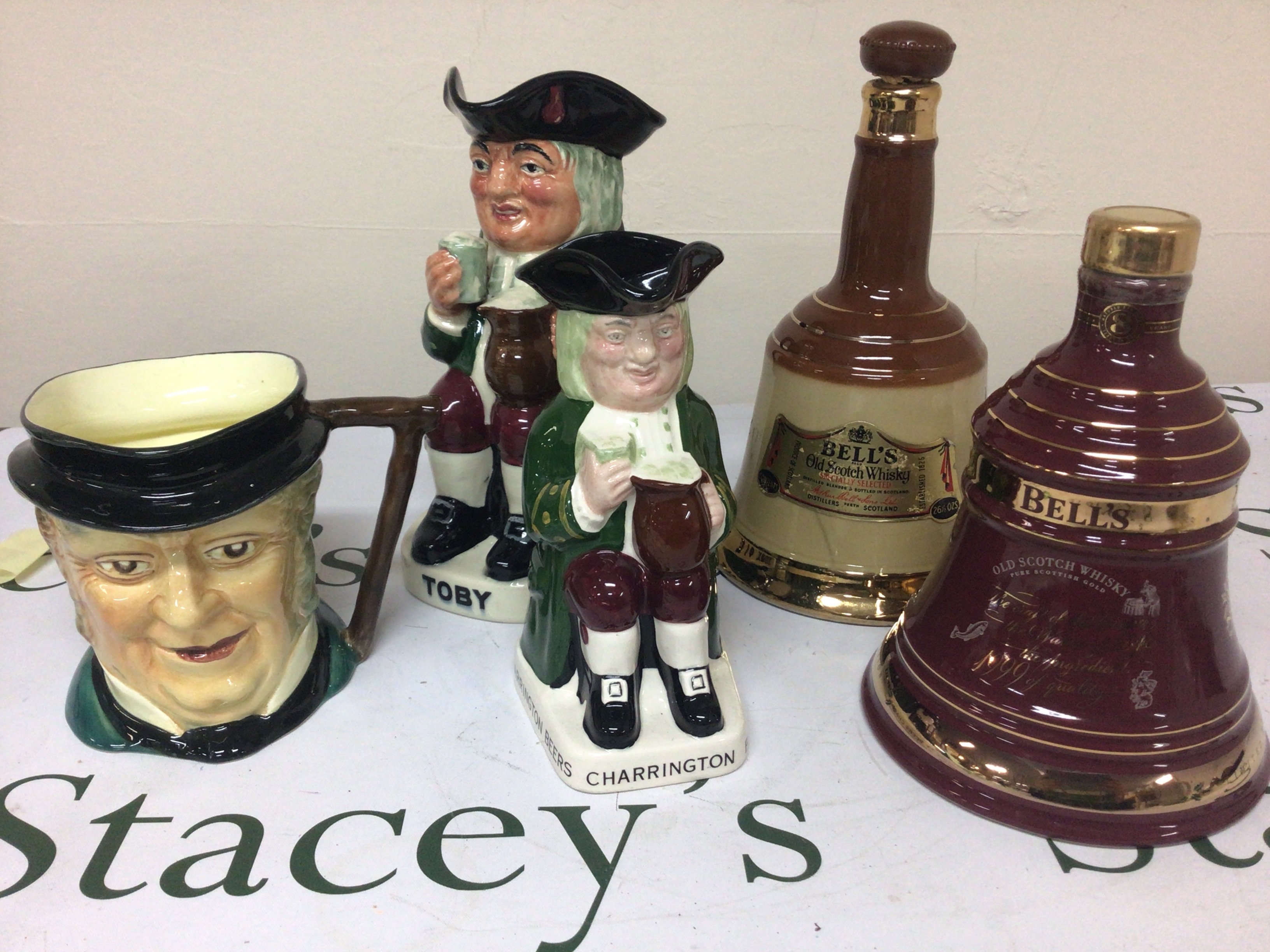 Two fubottles of Bells Whiskey Toby and Charrington caricature jugs and others.