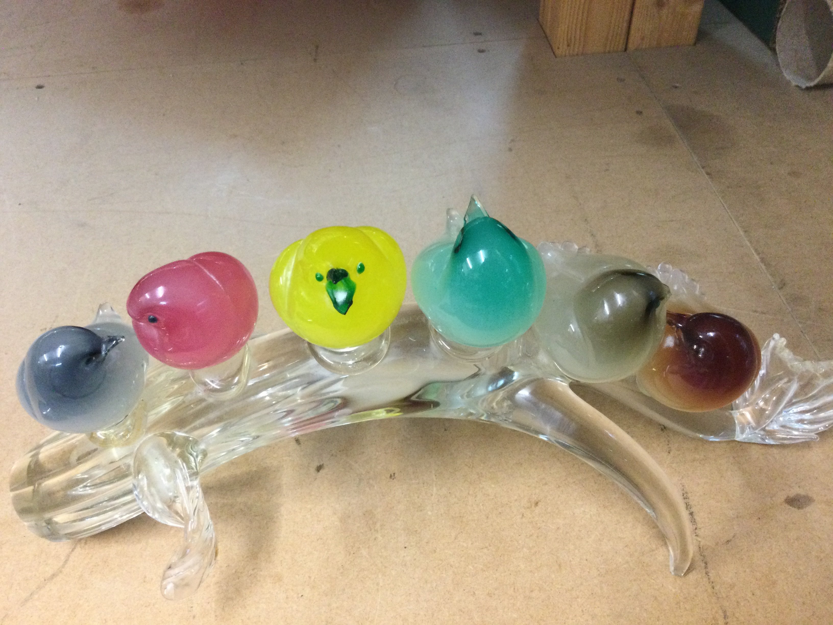 A Murano glass sculpture in the form six birds of various colours On a branch.