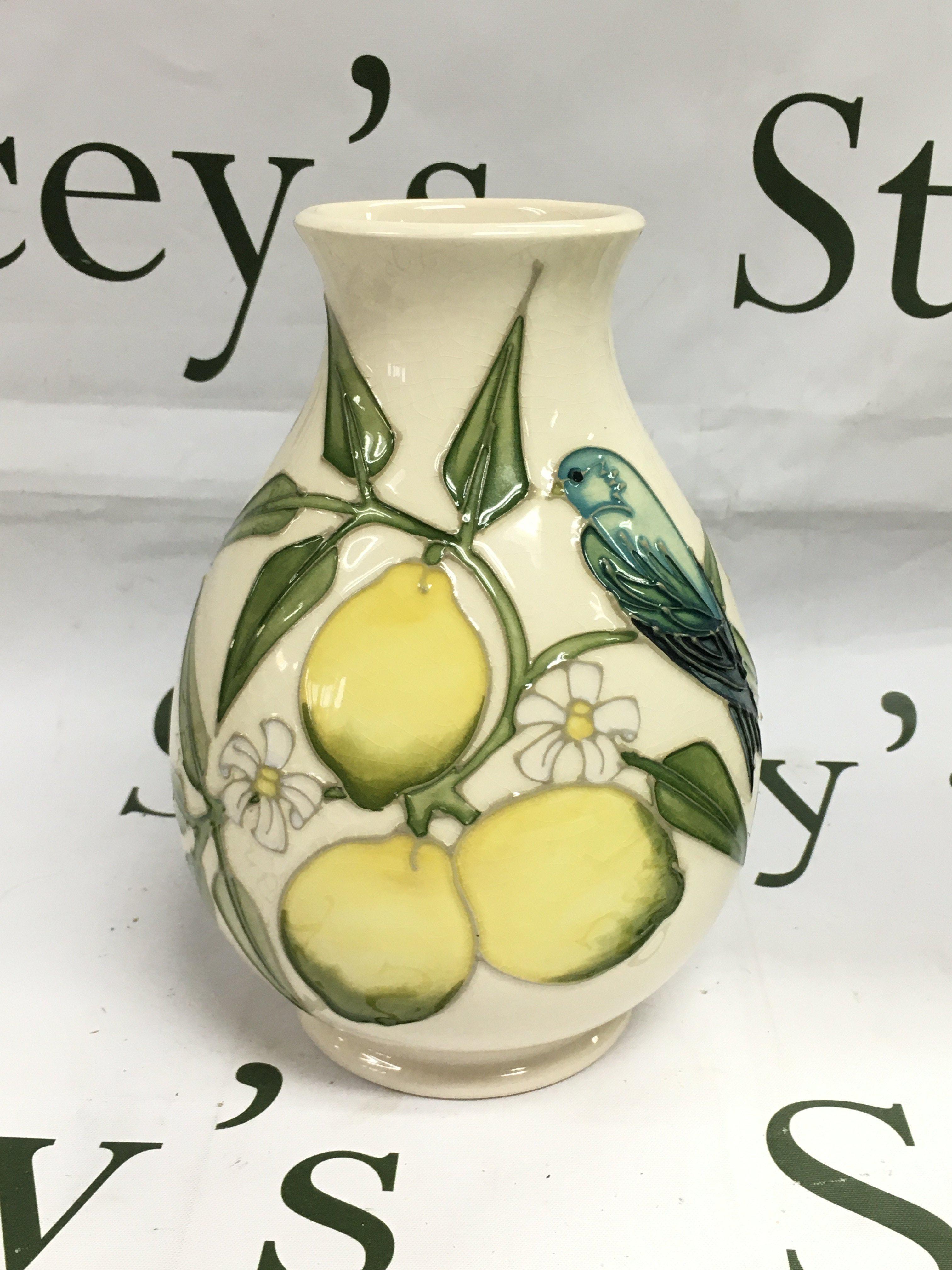 A Moorcroft vase in Lemons pawn, approx height 19cm and a conforming Moorcroft plate, approx diameter 25.5cm. Shipping category D.