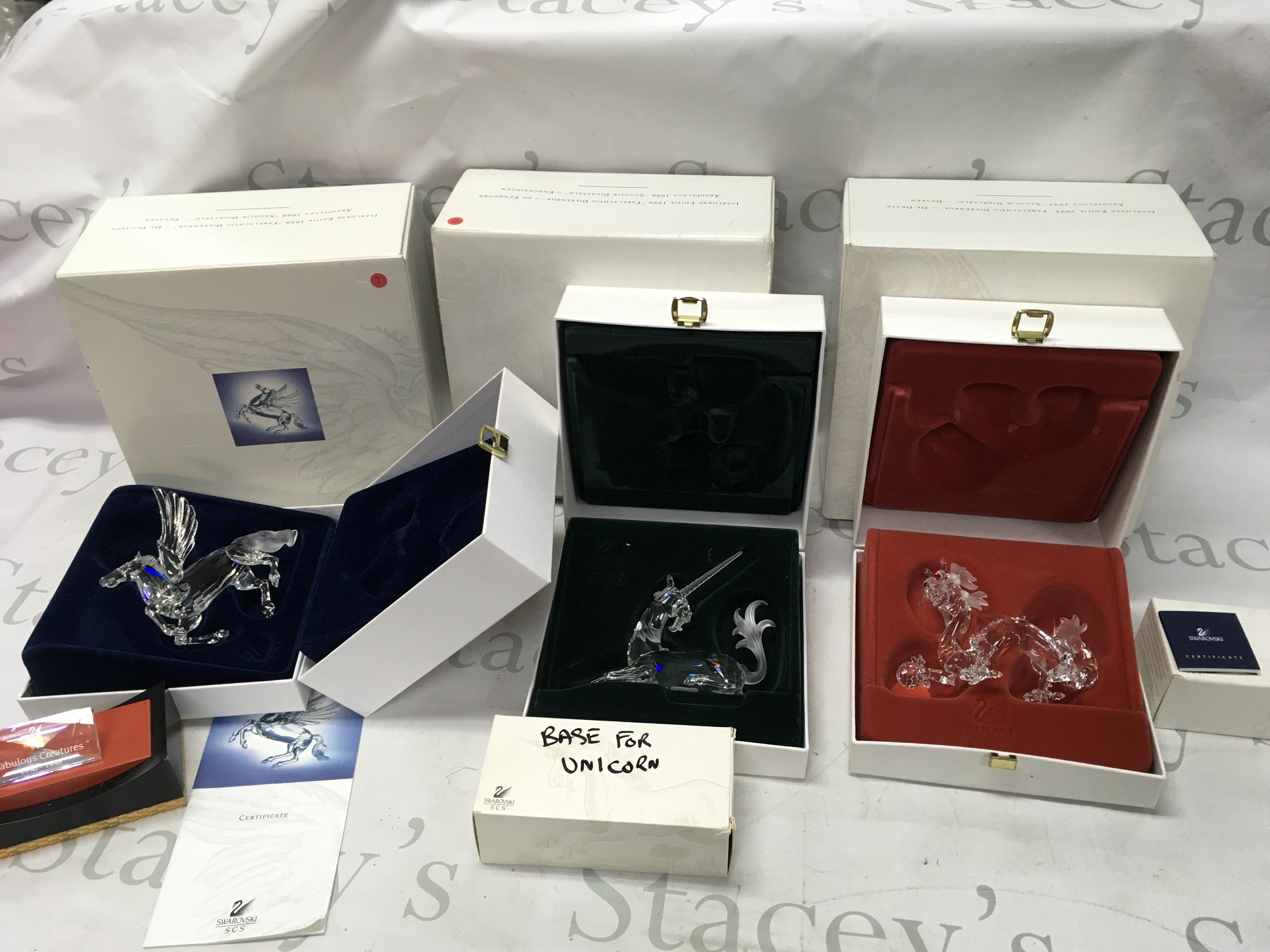 Three Swarovski Crystal fabulous creature figurines. All in boxes with their stands. One stand without its box and note very slight damage on ear of unicorn.