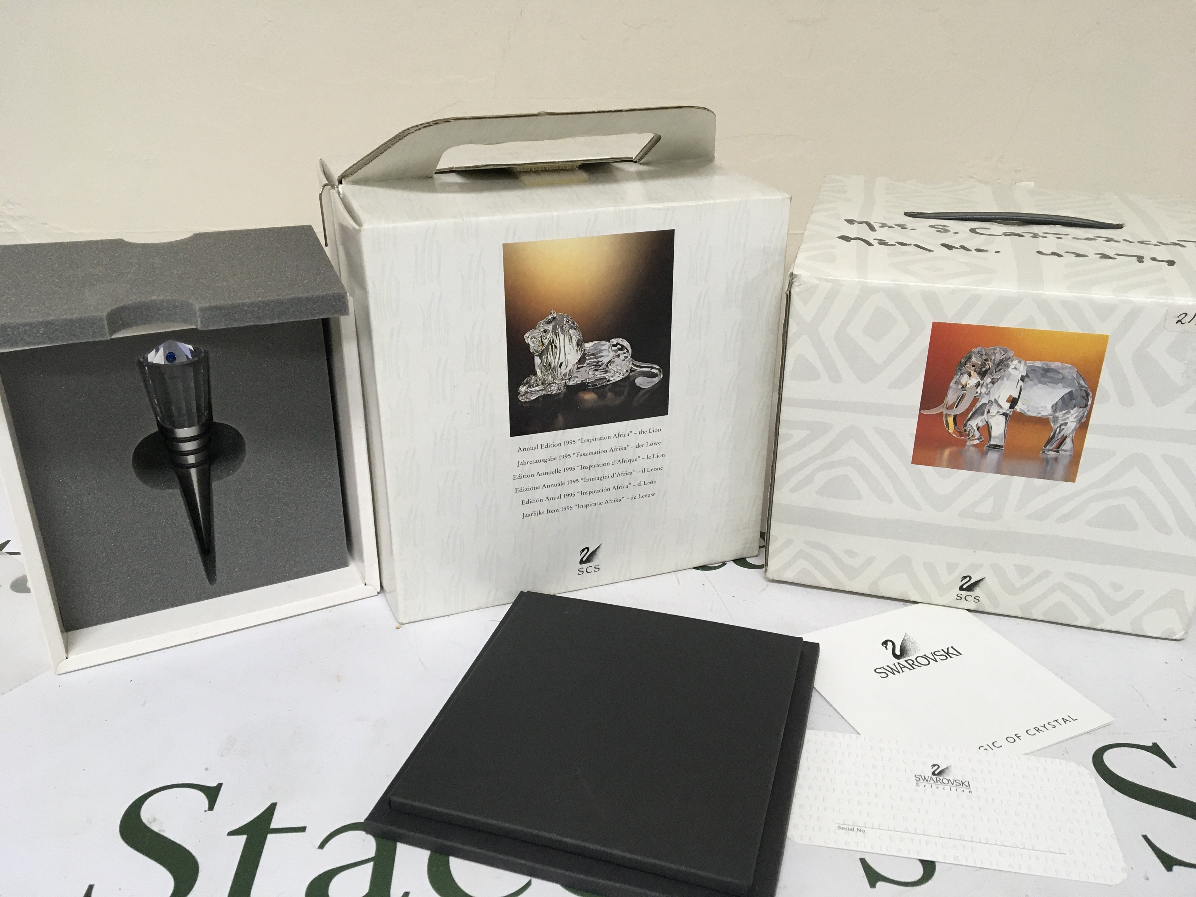 A boxed Swarovski 1995 Annual Edition Lion in a fitted box an elephant and a boxed glass bottle stopper (3)