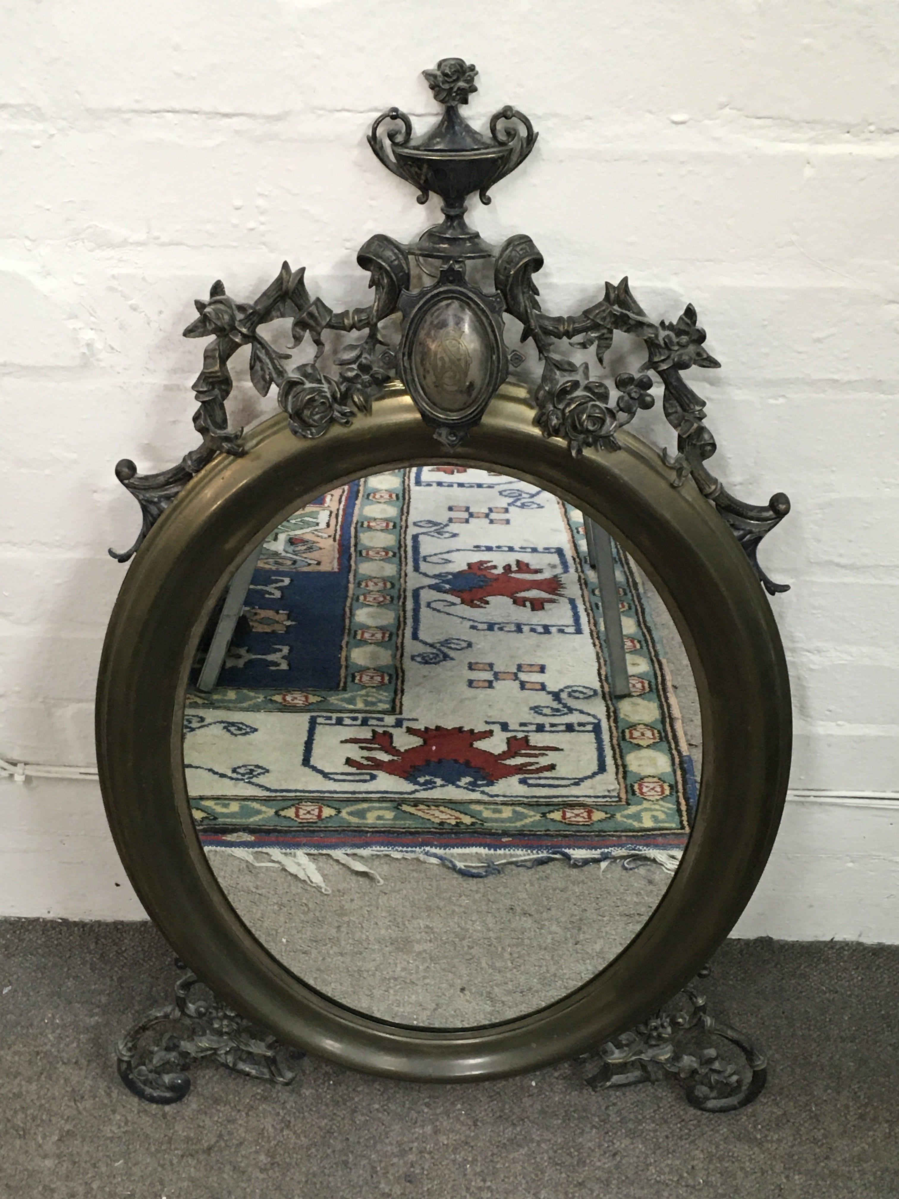 An ornate floral design oval mirror 45cm wide 82cm tall .this lot cannot be posted