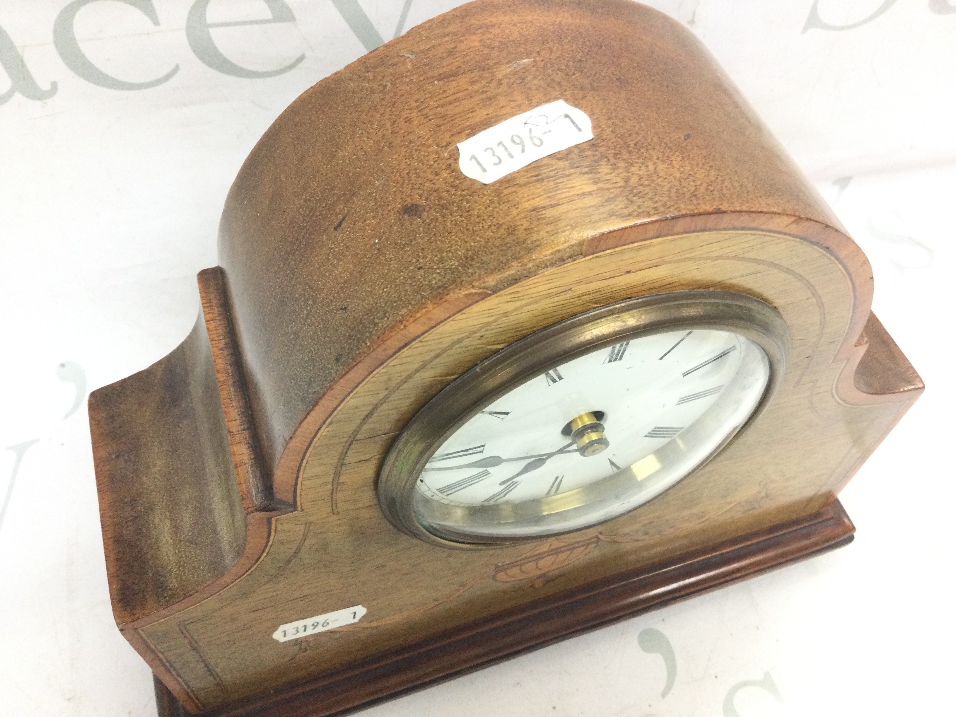 An Edwardian mantle clock with a French movement , inlaid design and key . Seen working. Dimensions 25 cm tall 21 cm wide. This lot cannot be posted- NO RESERVE