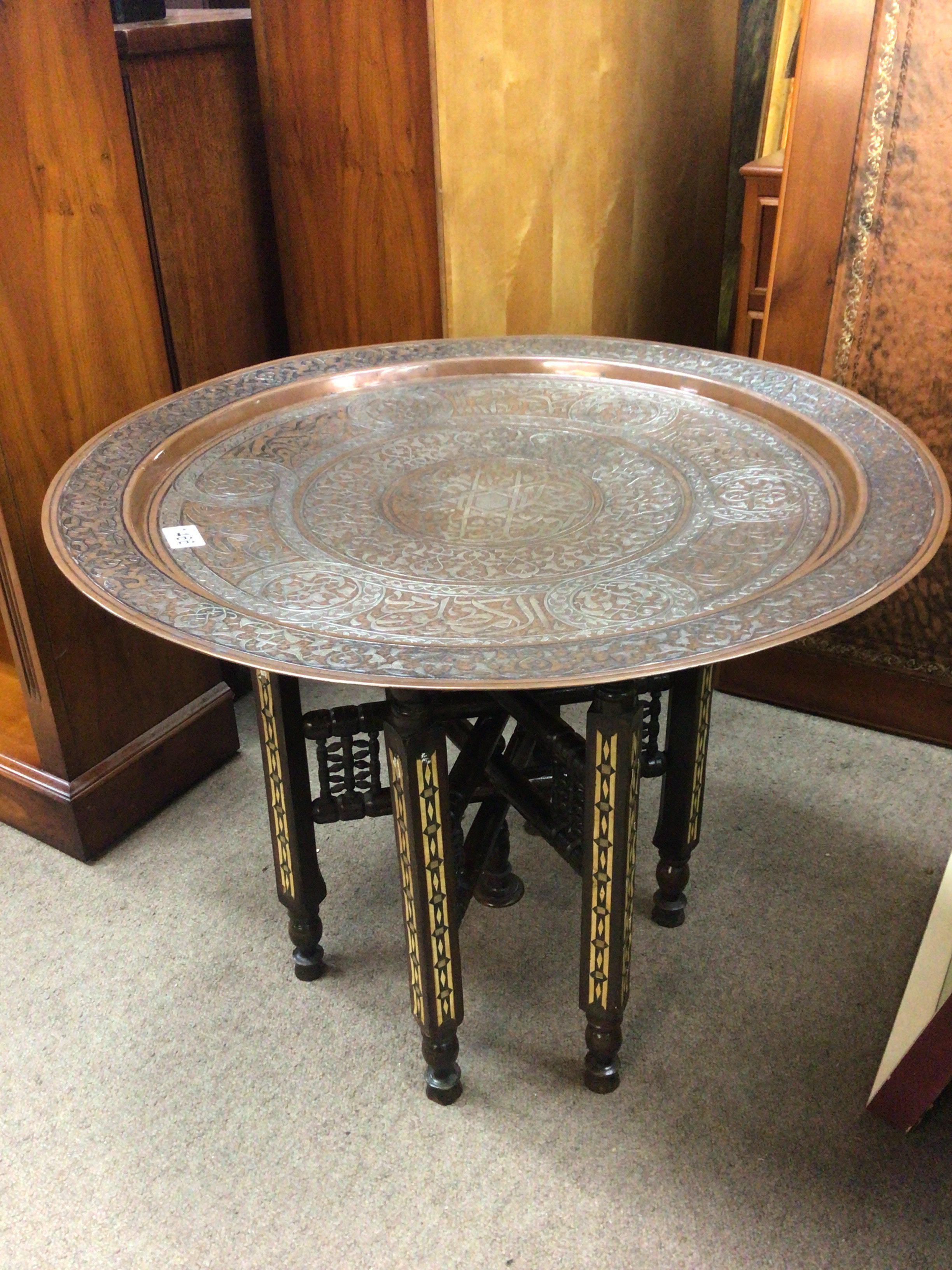 An Early 20th century or late 19th century Middle Eastern white metal inlaid Copper Circular shaped tray table. on a folding inlaid base. Diameter 70cm.